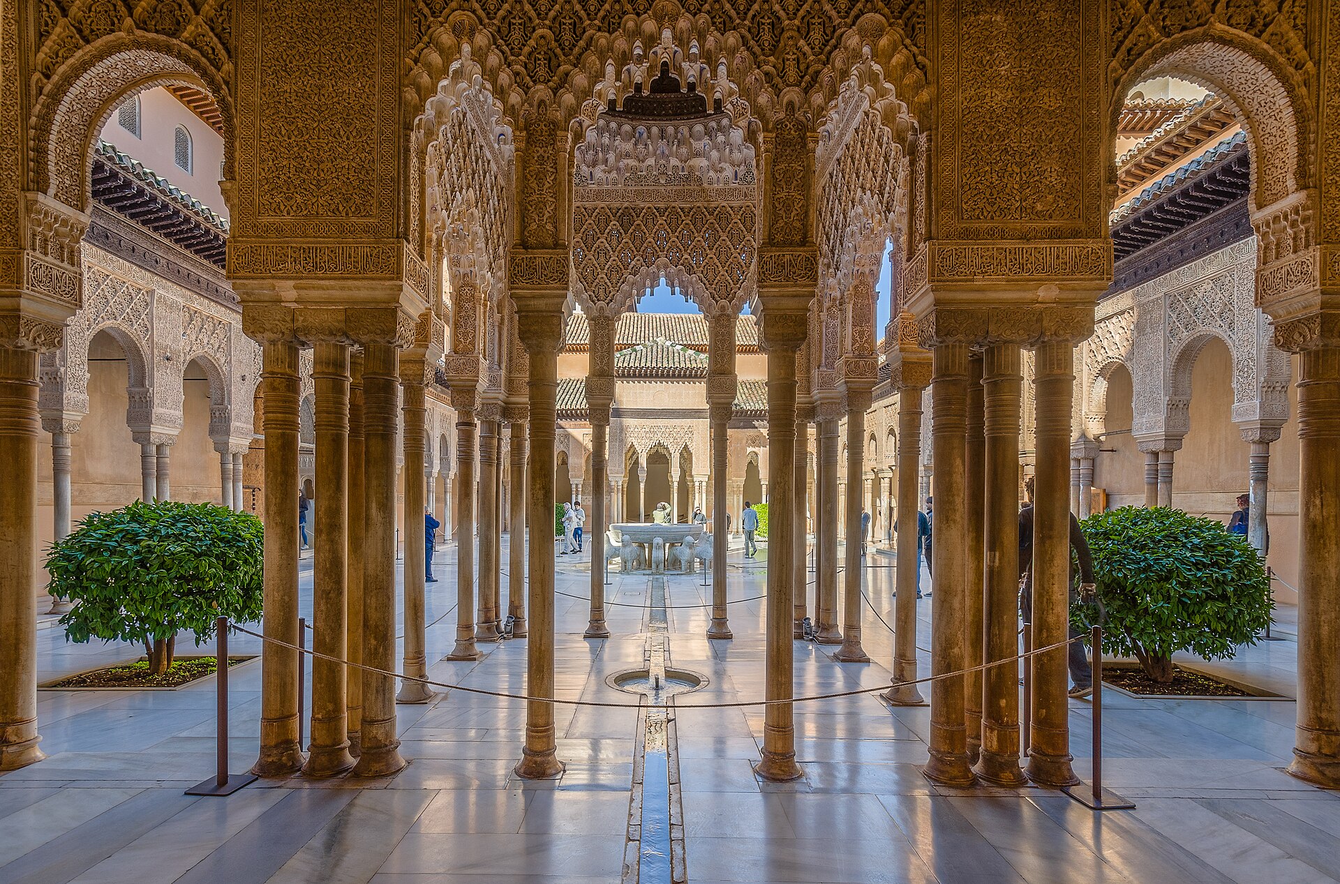 il patio de los leones dell’alhambra, visto fra le colonne sottili dei portici, con la fontana dei leoni al centro