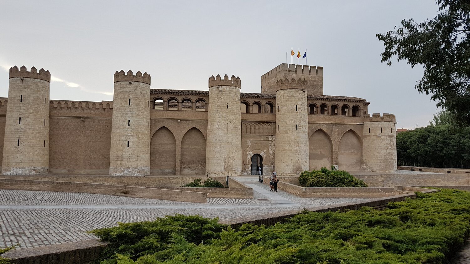 l’Aljafería di Saragozza al tramonto, con le mura di mattoni e le torri