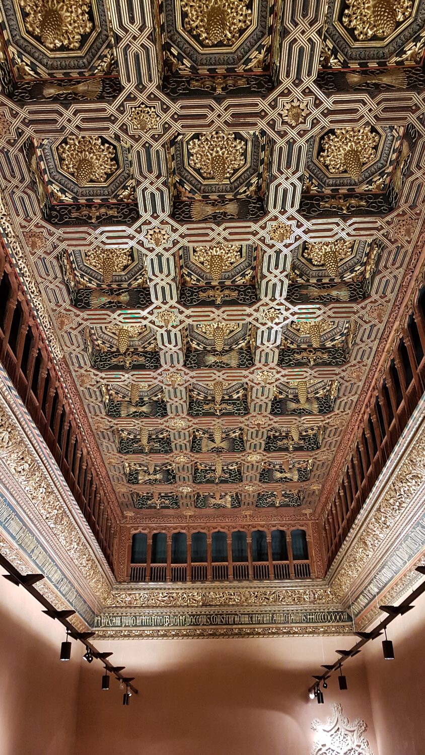 il soffitto ligneo dorato del Salone del Trono dell’Aljafería, con le pigne aggettanti e la fascia iscritta