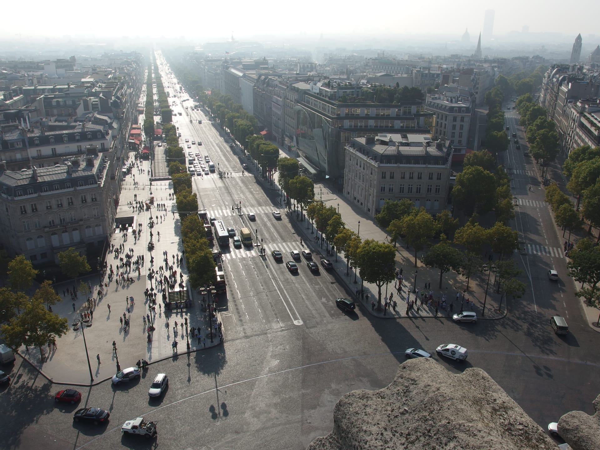 vista dall alto della terrazza dell arco di trionfo sugli champs elysees con gli edifici haussmanniani ai due lati e un angolo del cornicione in primo piano