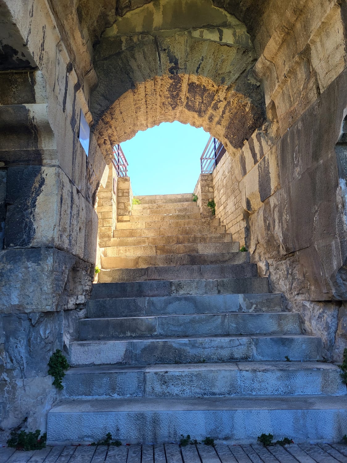 una escalera abovedada de la Arena de Nimes que sube hacia el cielo a través del arco de un vomitorio
