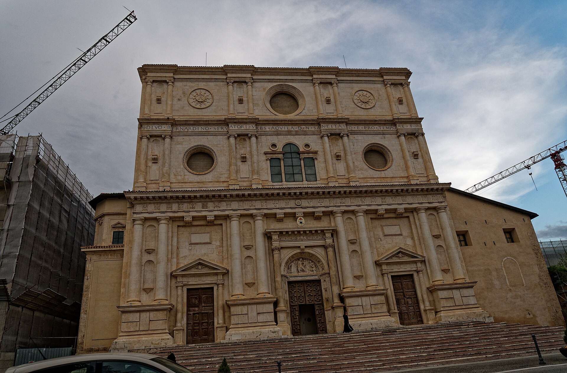 la facciata a tre ordini della basilica di san bernardino con colonne accoppiate oculi e l iscrizione latina nel fregio