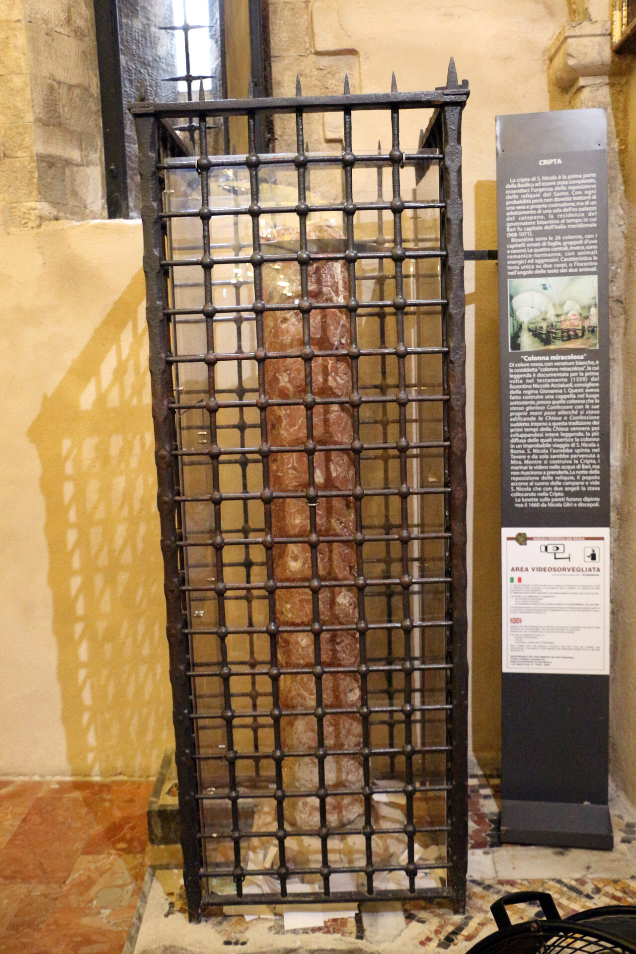 the miraculous column in the crypt of the basilica of san nicola in bari behind its iron grille