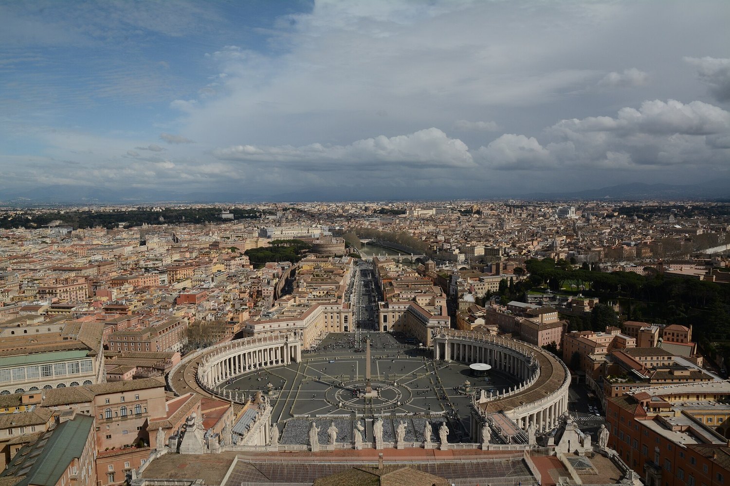 la vista dalla cupola di San Pietro su piazza San Pietro con il colonnato di Bernini, l'obelisco e Roma fino ai monti