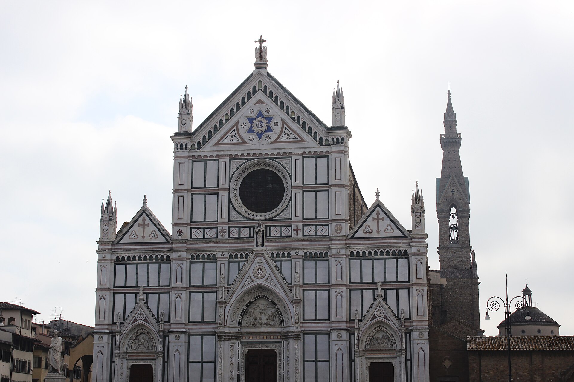 la facciata policroma di santa croce a firenze con il rosone e il campanile accanto