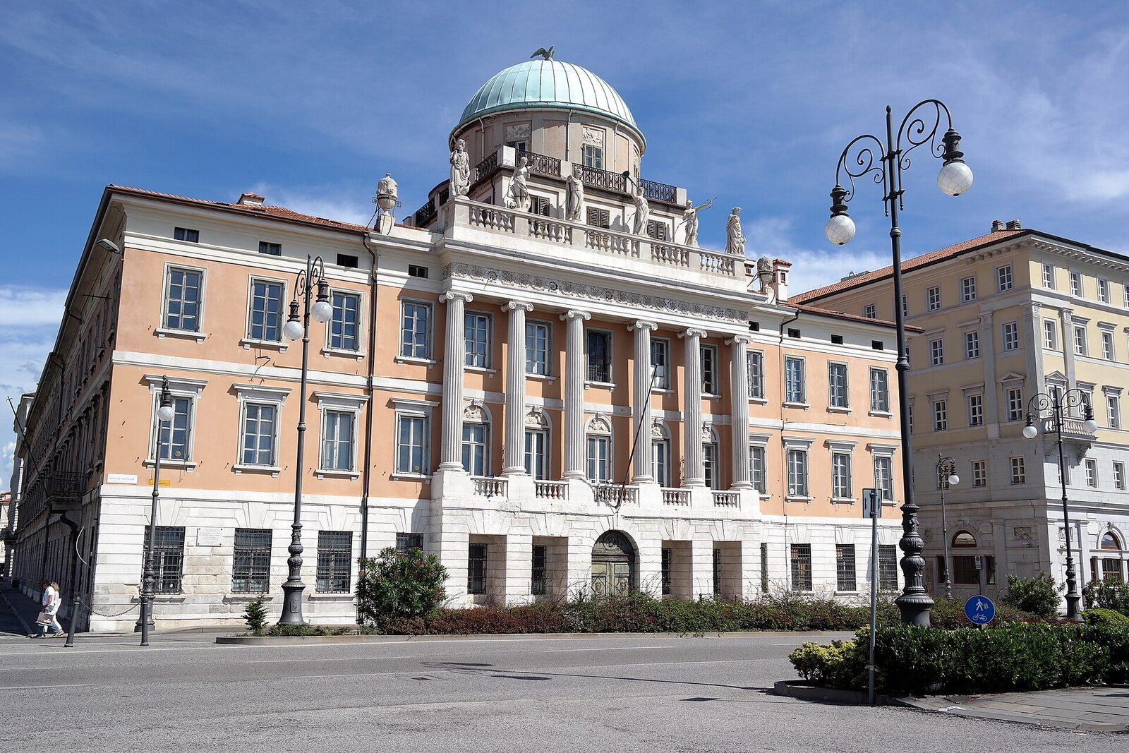 palazzo carciotti a trieste con la cupola verde e il colonnato ionico visto dalla strada