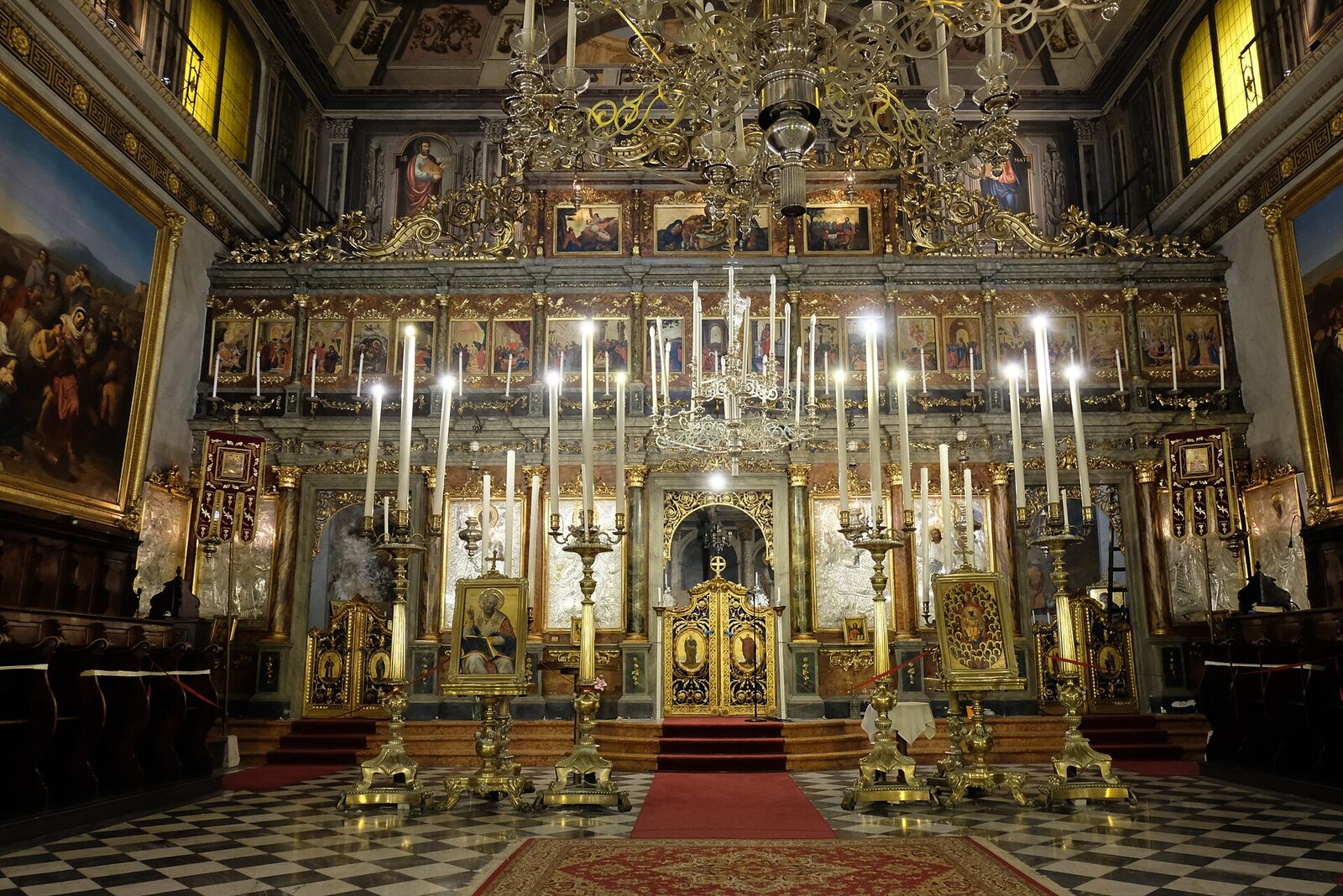 l interno di san nicolo dei greci a trieste con l iconostasi dorata i grandi candelabri e il pavimento a scacchi