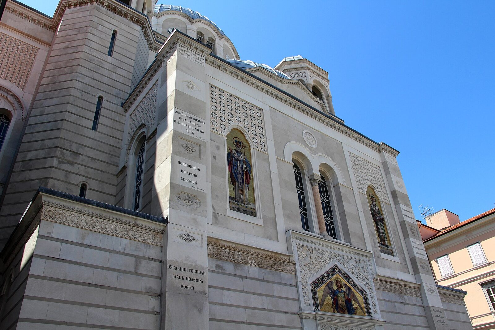 dettaglio esterno del tempio di san spiridione a trieste con i mosaici le iscrizioni in cirillico e le cupole azzurre