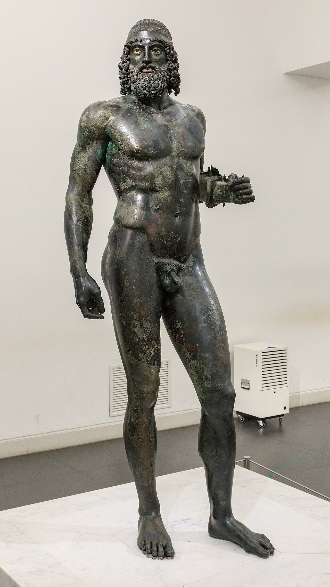 il bronzo a di riace intero visto di fronte con la fascia sui capelli e la barba