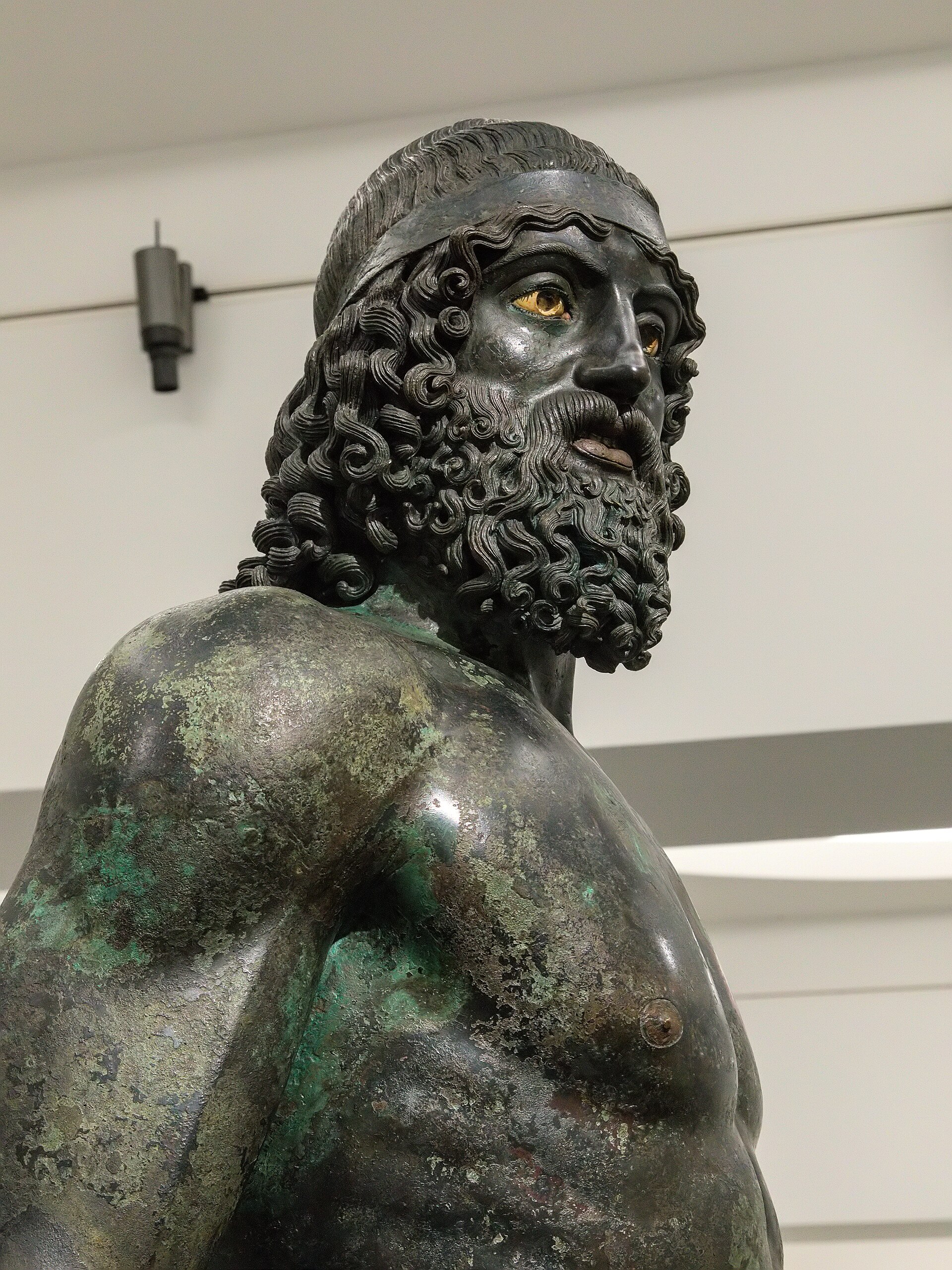 dettaglio della testa del bronzo a di riace con la barba riccia e gli occhi in calcite e pasta vitrea