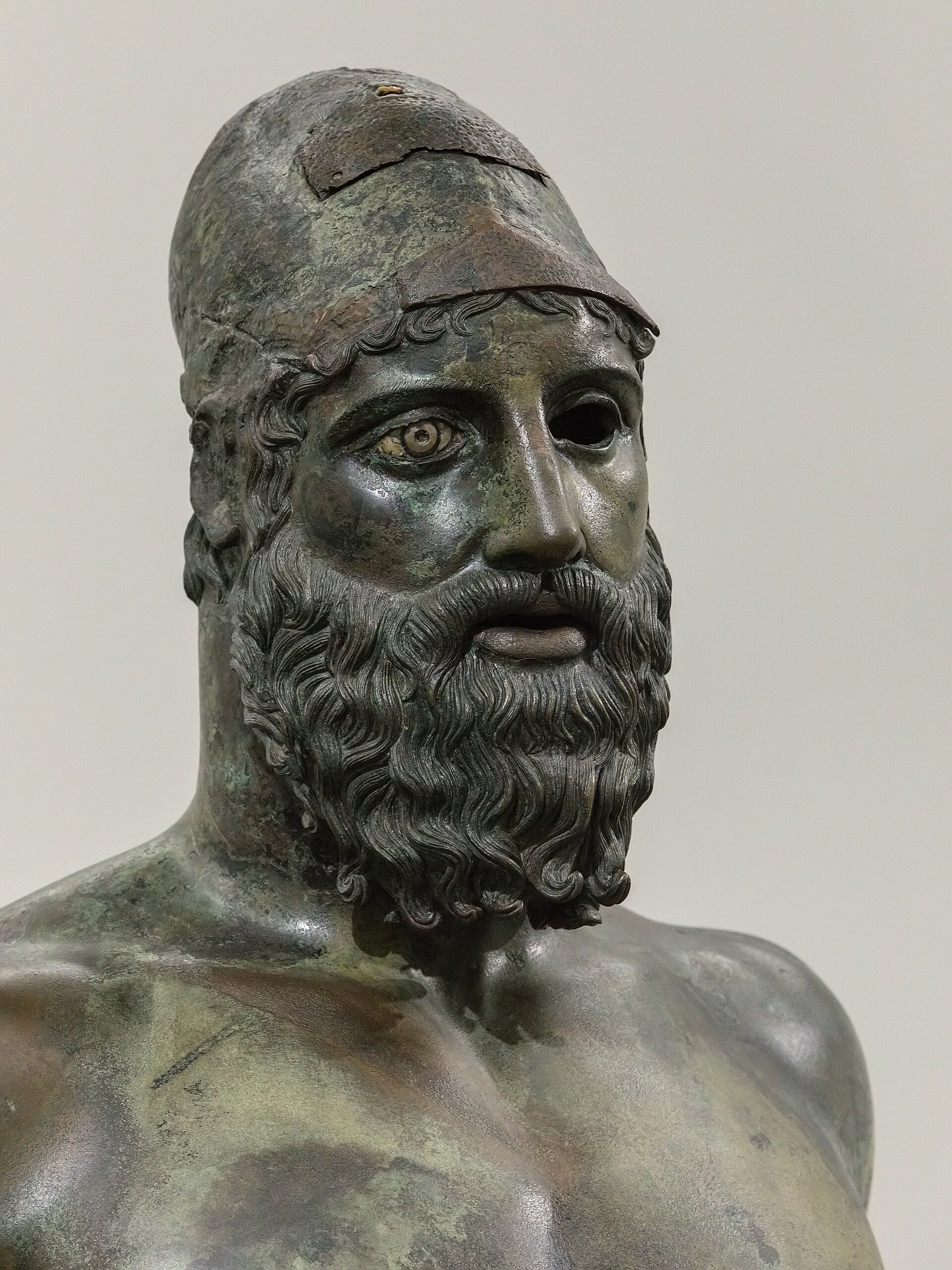 dettaglio della testa del bronzo b di riace con la calotta sui capelli e l occhio destro mancante