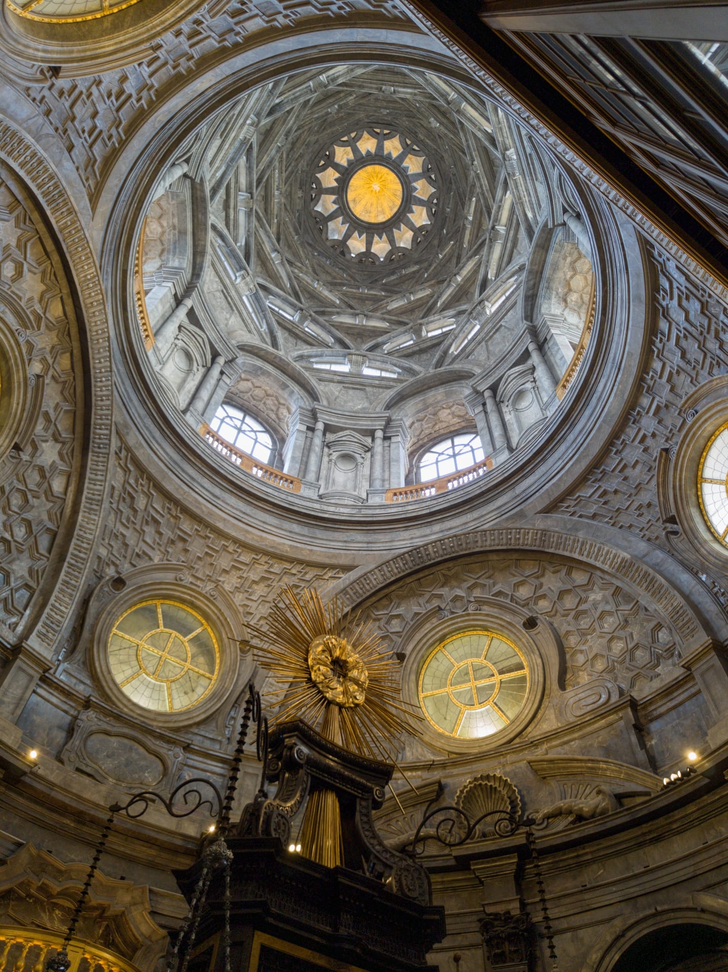 the interior of the chapel of the holy shroud in turin after the restoration, with the dark marble and light from the windows
