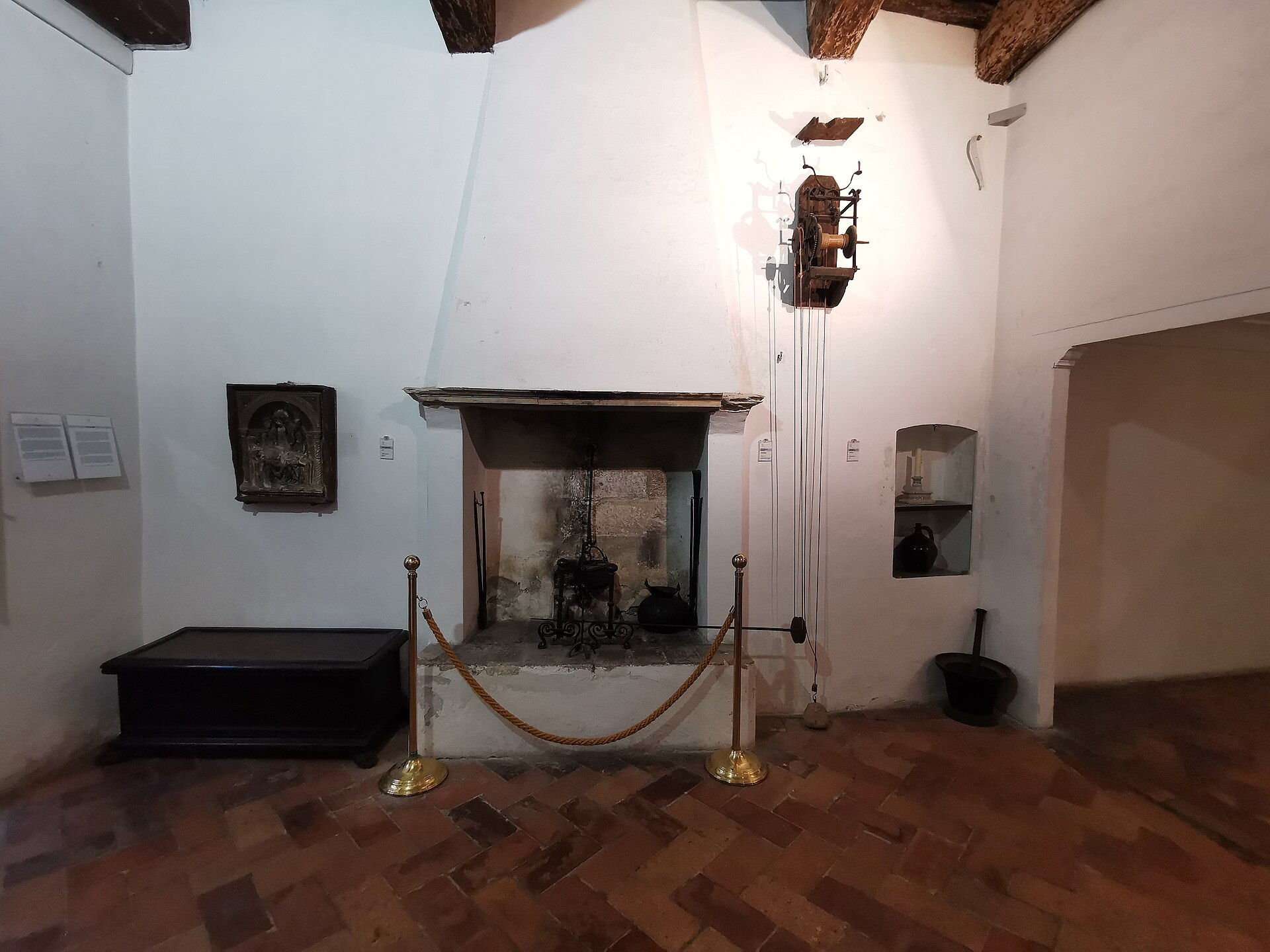 room of raphael’s birthplace with a fireplace, terracotta floor and exposed beams