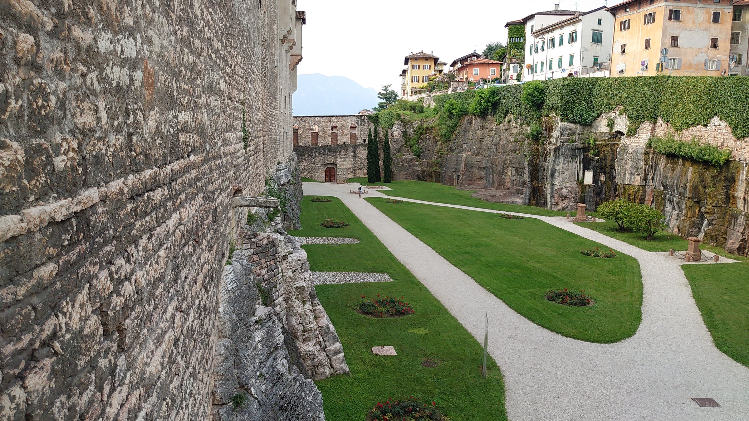 la fossa del castello del buonconsiglio a trento con il prato e i cippi commemorativi