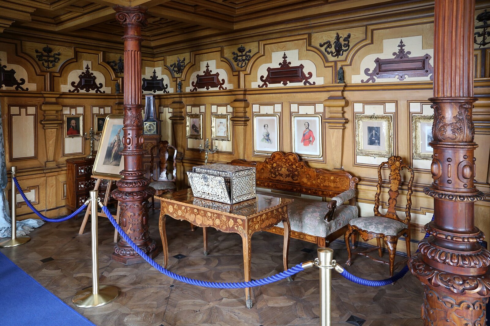 la sala novara nel castello di miramare con i rivestimenti di legno le colonne e i ritratti alle pareti