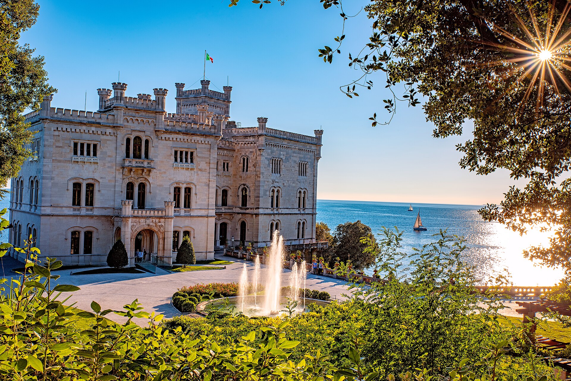 il castello di miramare bianco sul promontorio con la fontana del giardino e il golfo di trieste