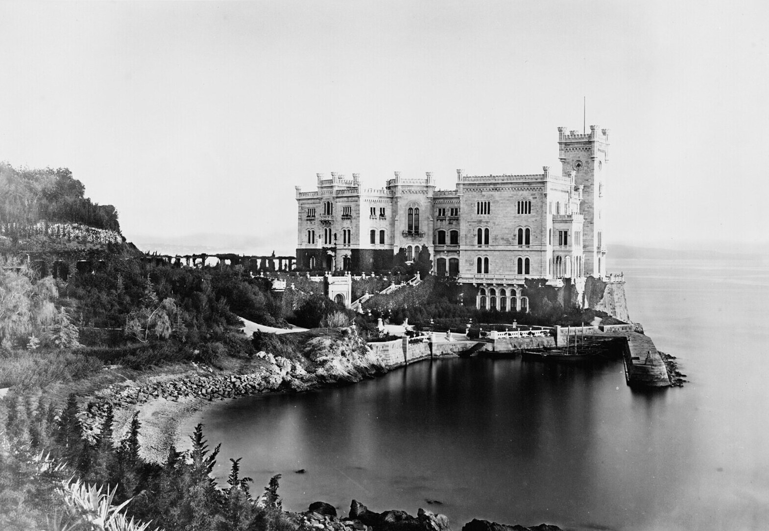 fotografia ottocentesca del castello di miramare con il promontorio ancora spoglio e il porticciolo