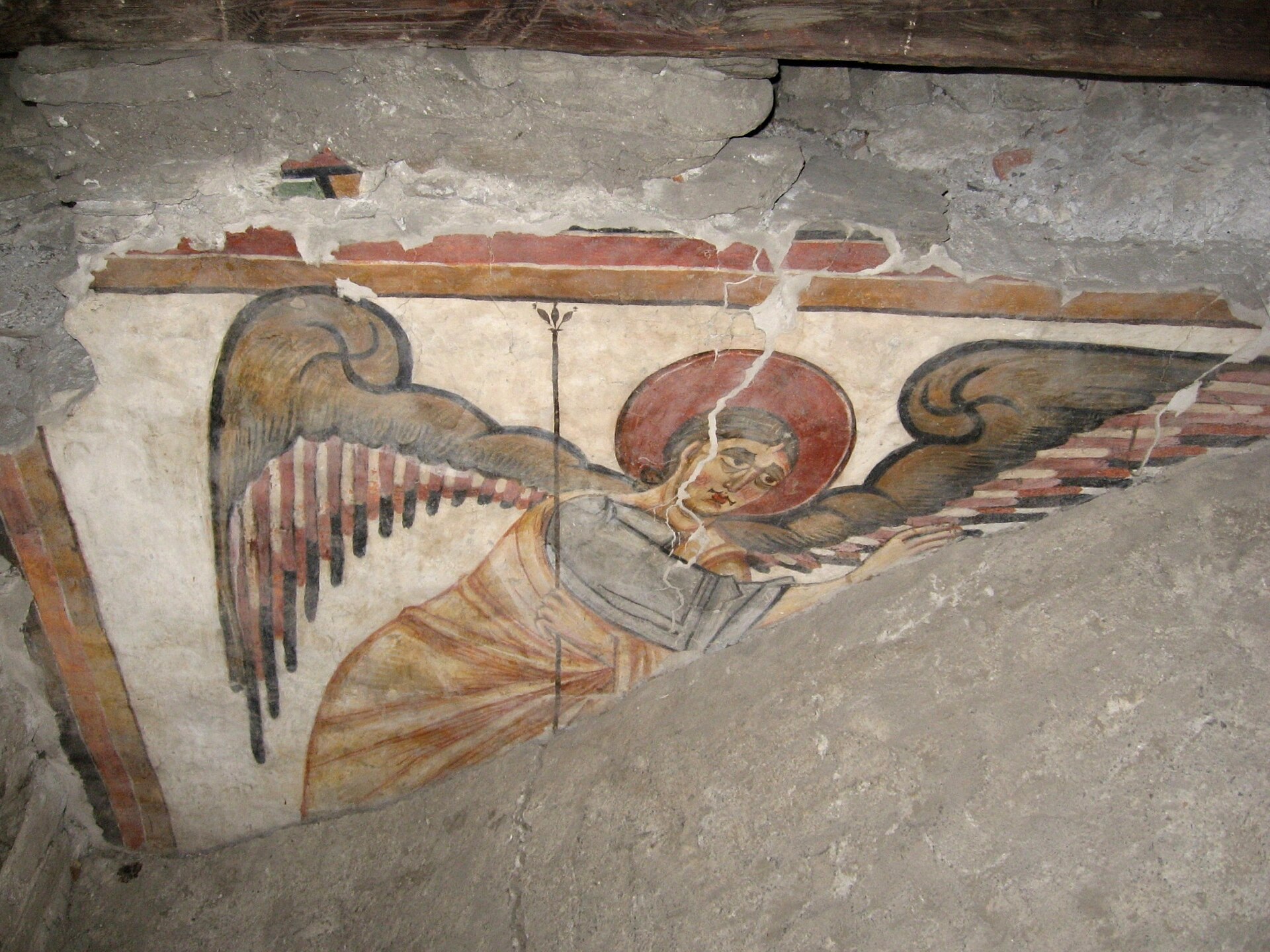 un affresco ottoniano del sottotetto della cattedrale di aosta, un angelo con le ali spiegate e il nimbo rosso su un frammento di intonaco