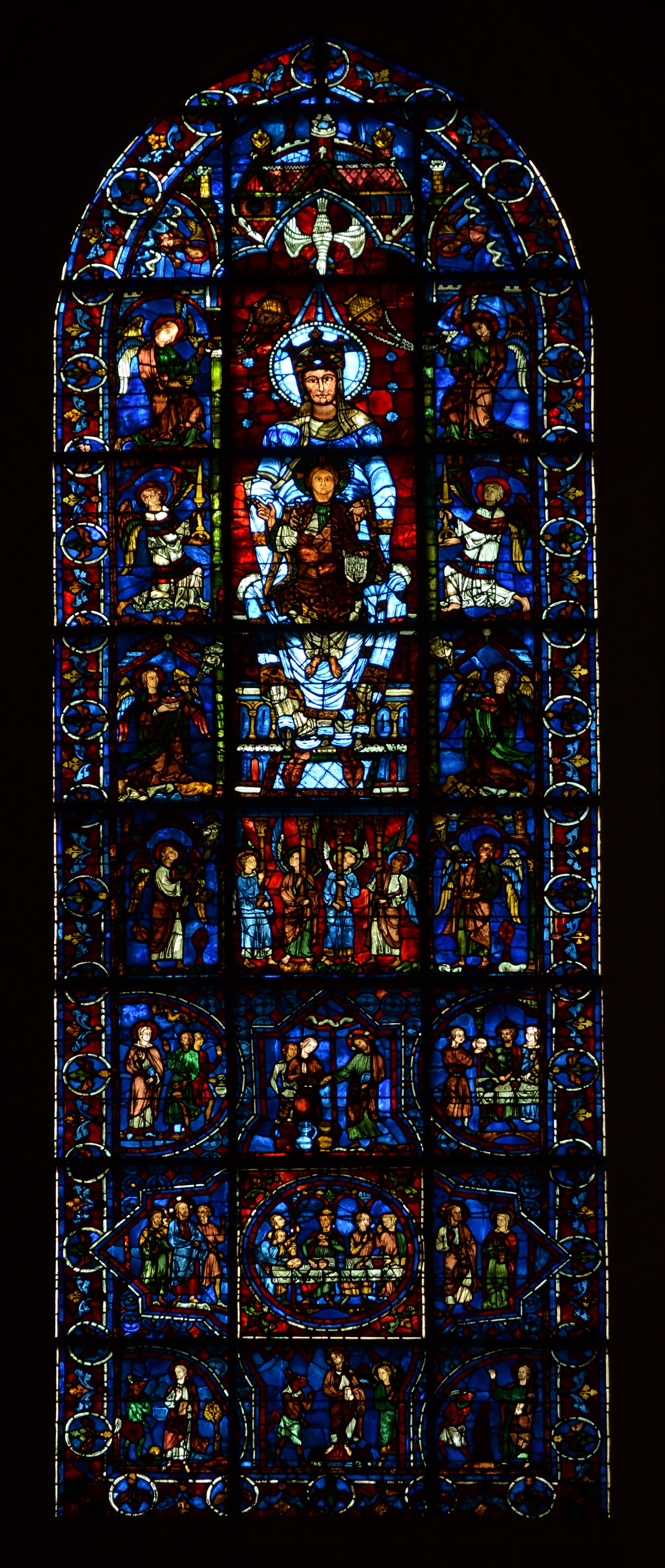la vetrata della madonna della bella vetrata a chartres, con la vergine in trono e il bambino su fondo blu, circondata da angeli e scene narrative nei registri sottostanti