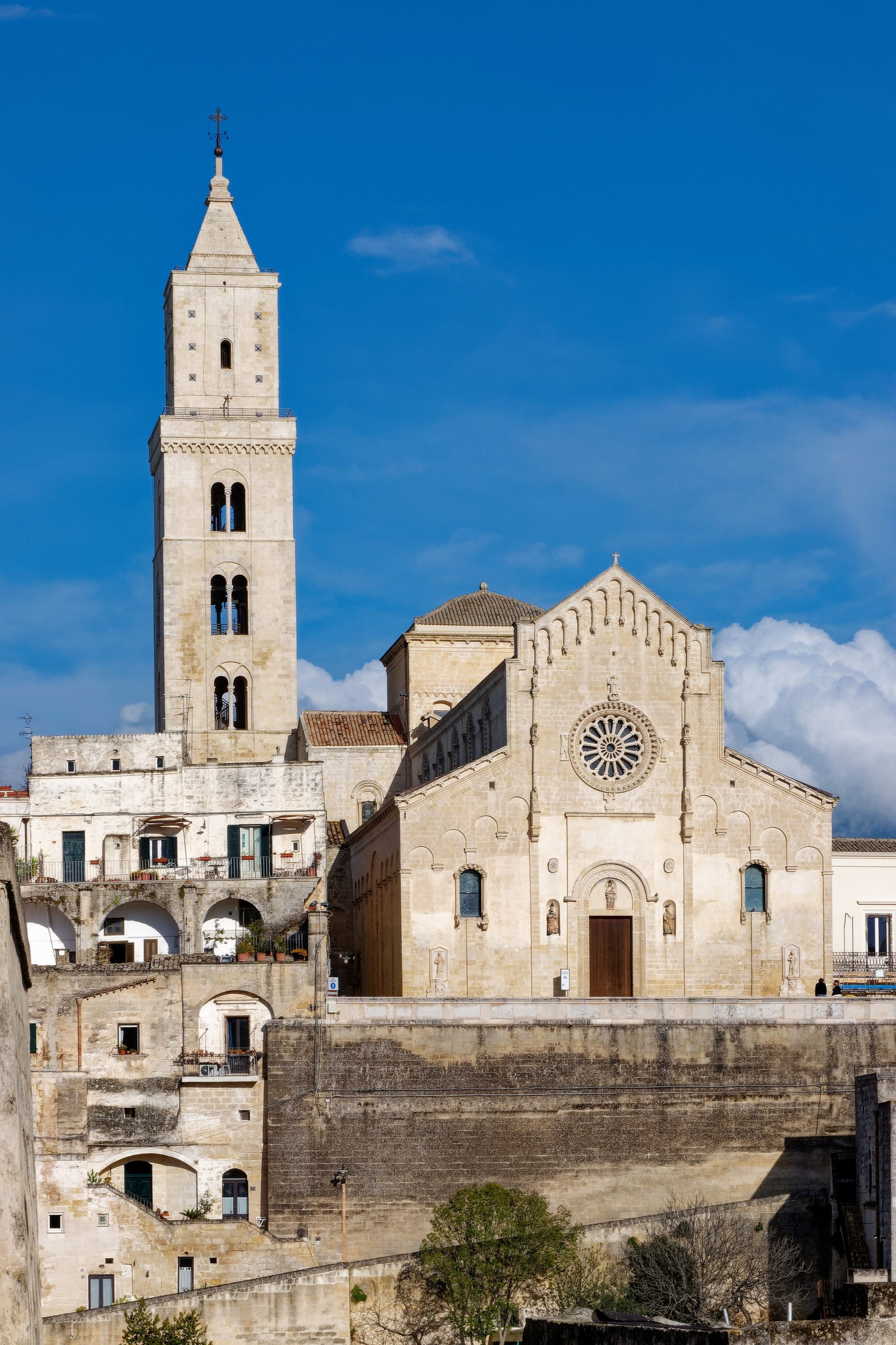 la facade de la cathedrale de matera avec la rosace et le clocher vus au dessus des toits des sassi