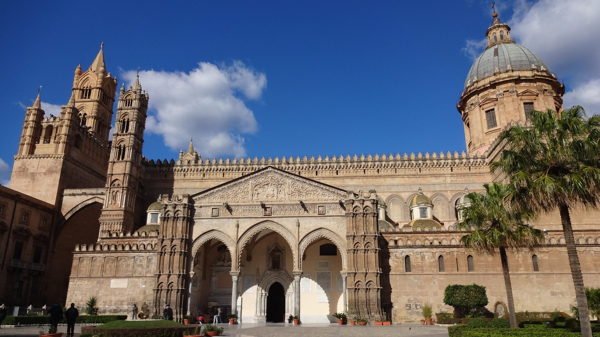 palermo cathedral seen from the south side with its crenellated towers the apses and the palms