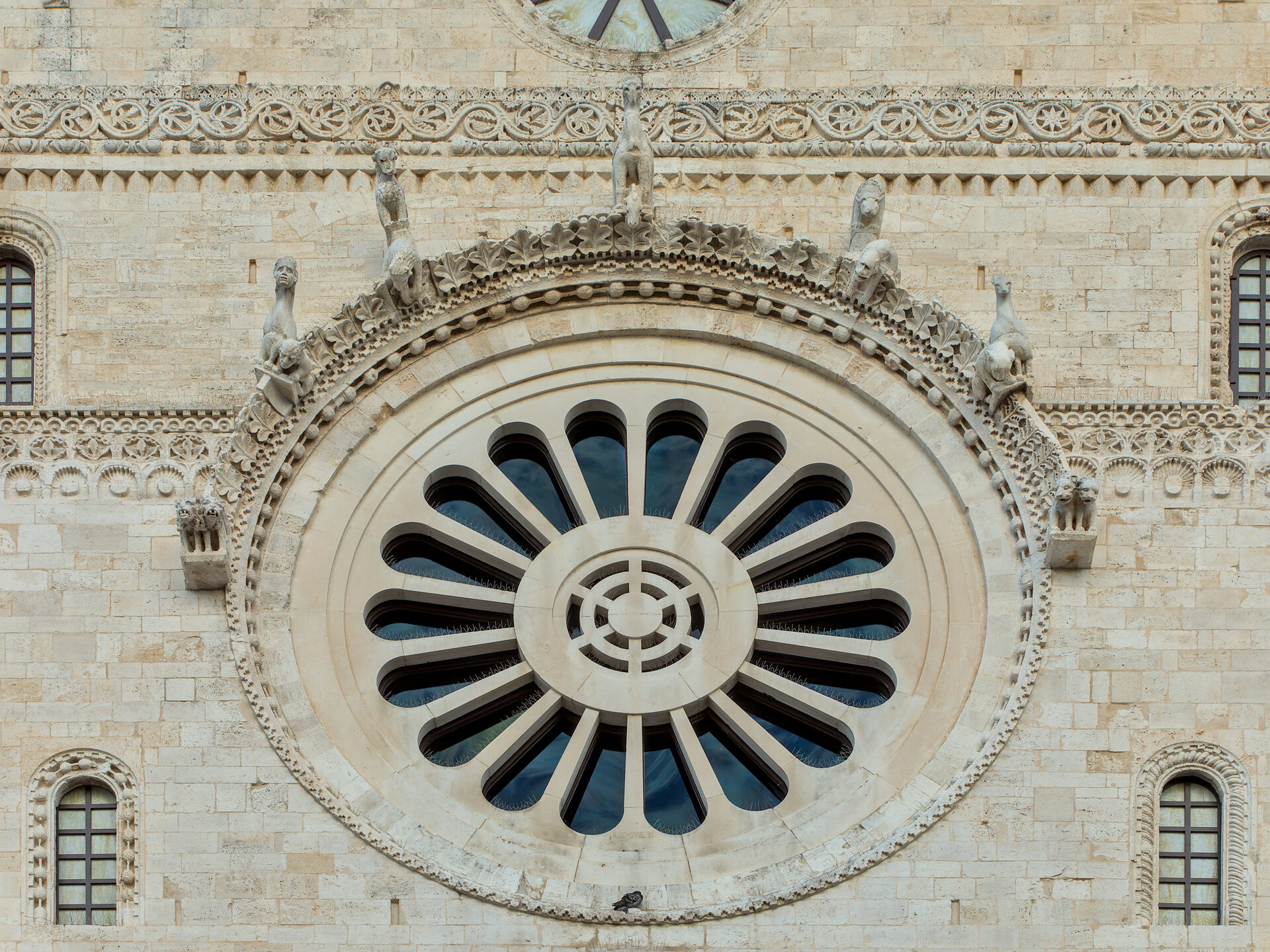 the rose window on the façade of the cathedral of san sabino in bari with its carved frame and grotesque corbels