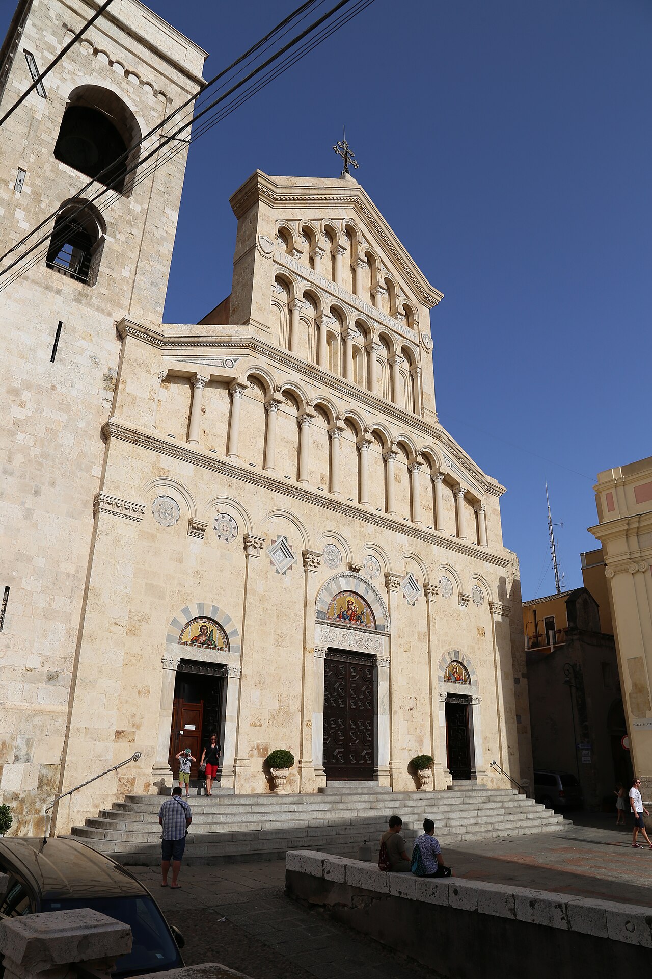 la facciata neoromanica della cattedrale di cagliari con il campanile a sinistra e i tre portali con i mosaici
