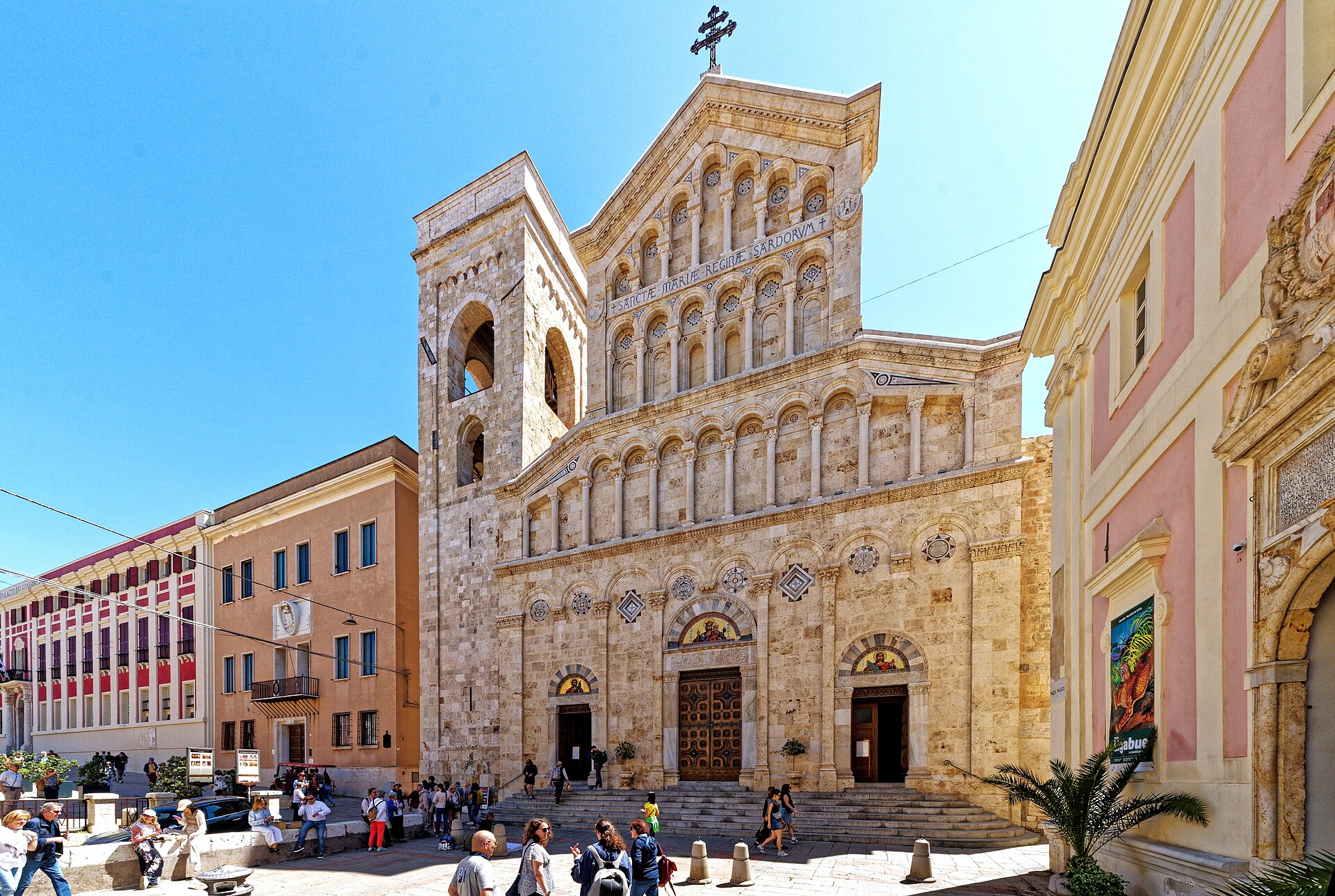 la facciata della cattedrale di santa maria a cagliari con il campanile a sinistra e il cielo azzurro