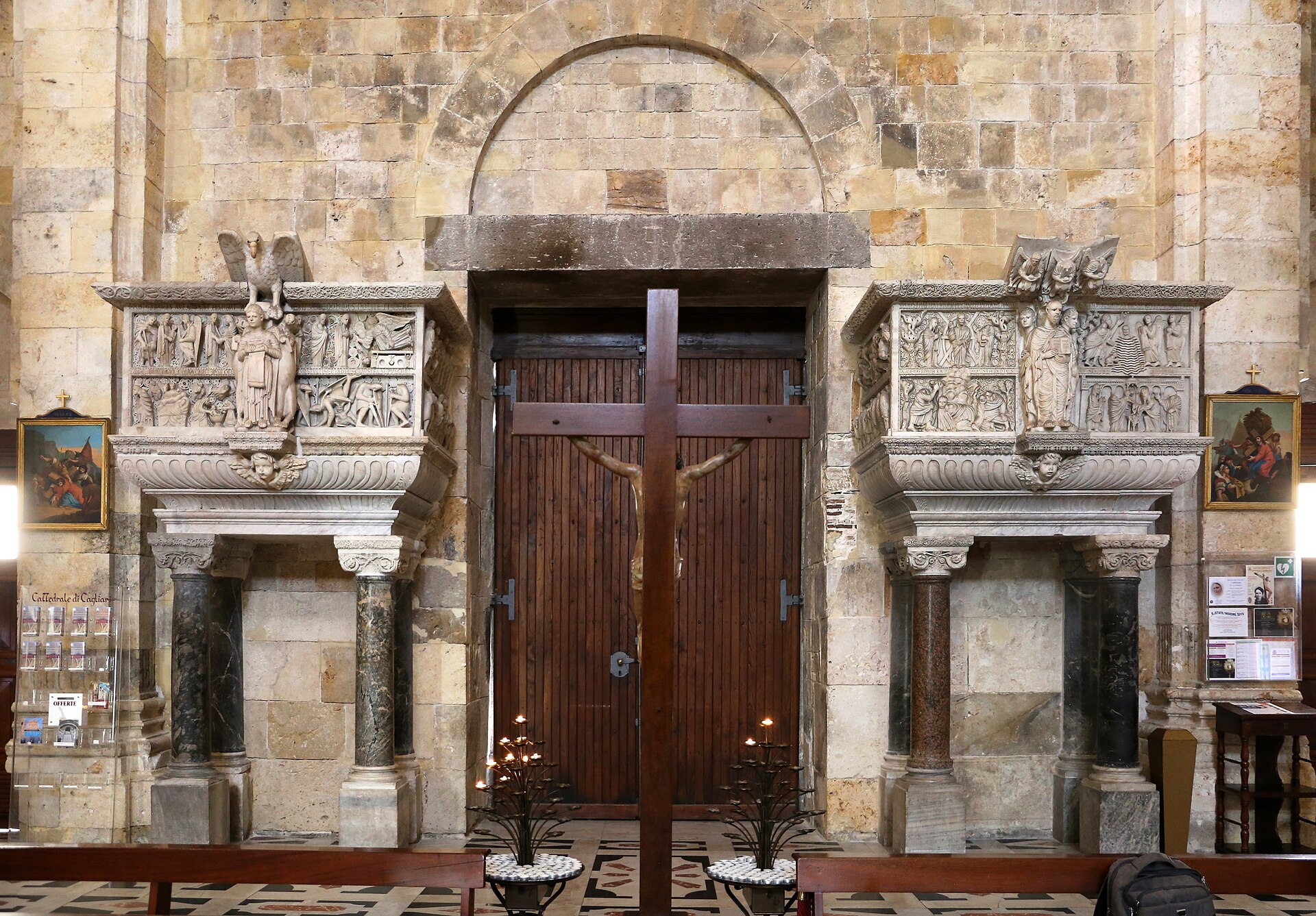 i due pergami marmorei di maestro guglielmo ai lati del portale interno della cattedrale di cagliari con il crocifisso al centro