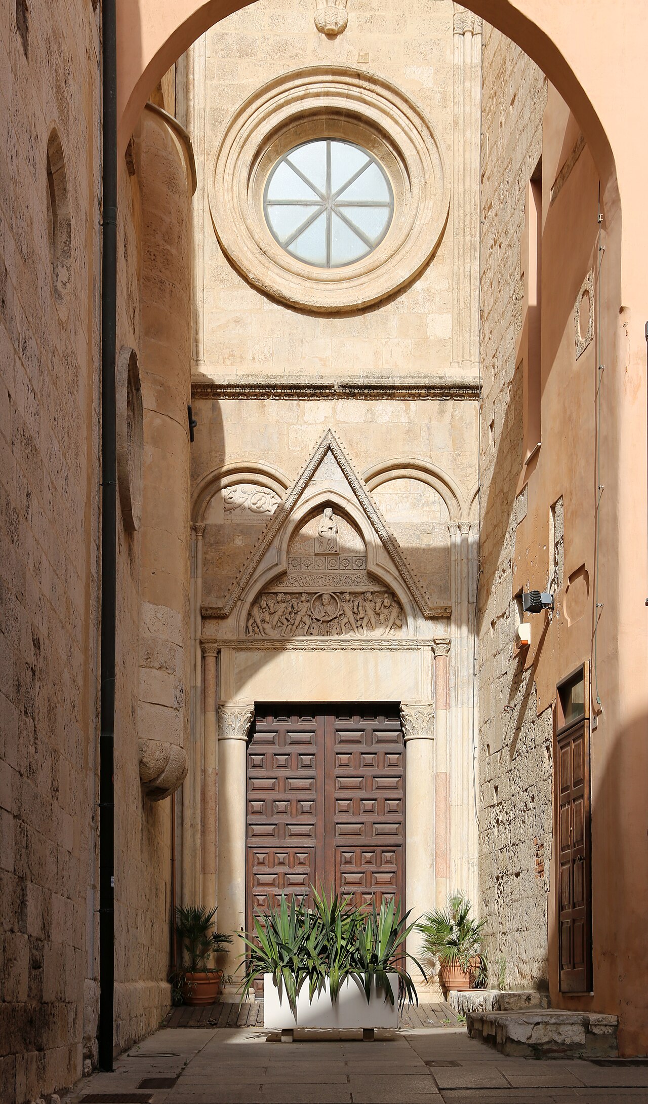 portale gotico pisano sul fianco della cattedrale di cagliari con materiale di spoglio e un sarcofago romano