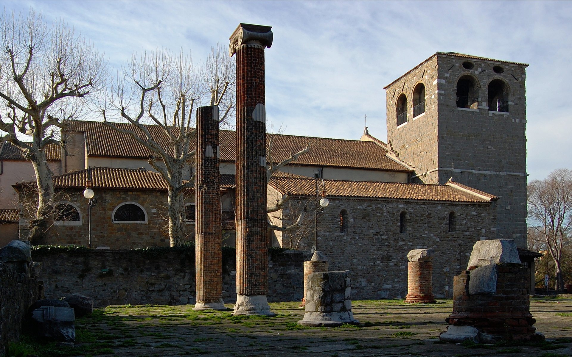 la cattedrale di san giusto vista dal foro romano con le due colonne rialzate e il campanile