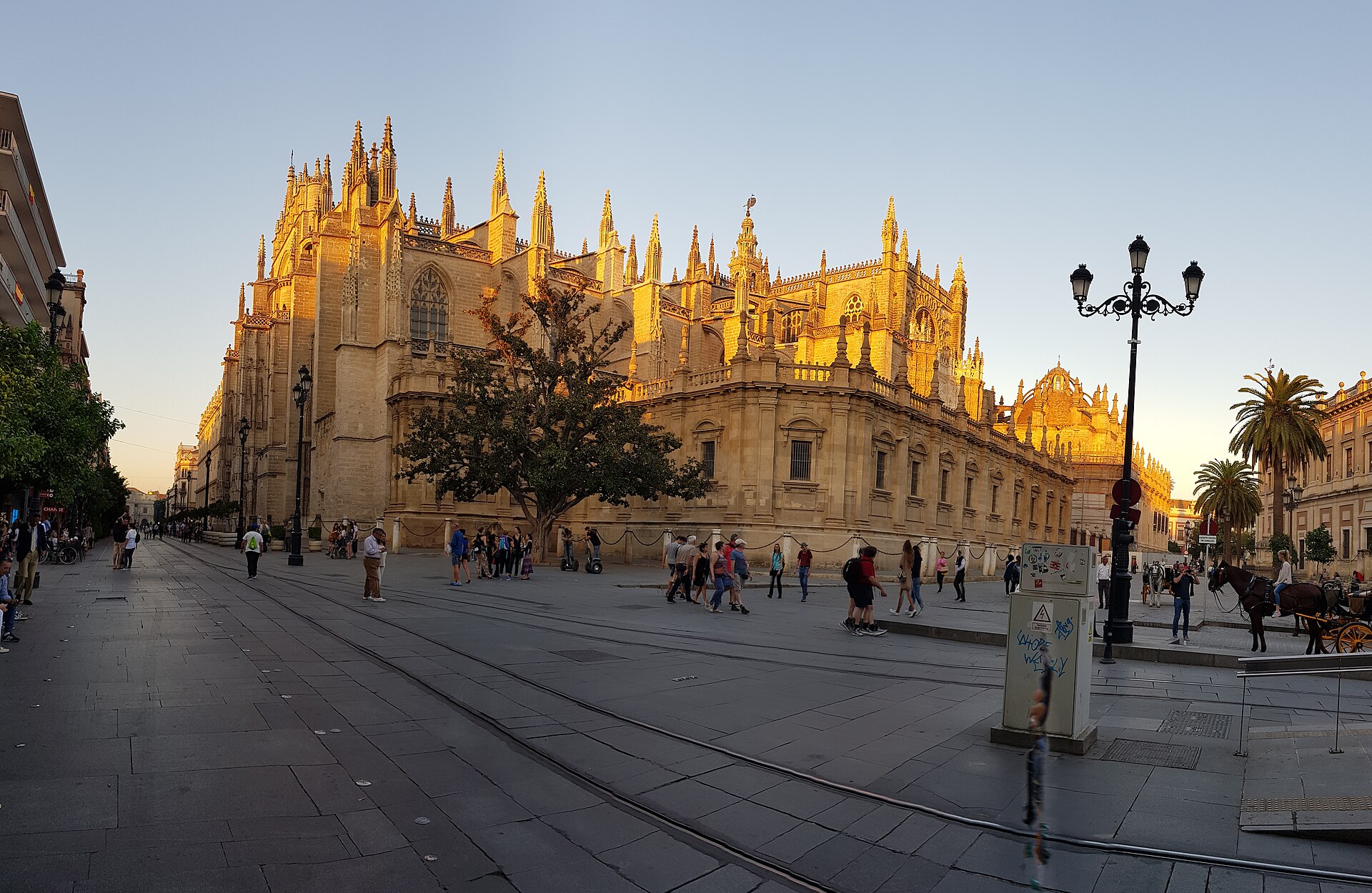 il fianco della cattedrale di siviglia con le guglie gotiche e i contrafforti, visto dall’avenida de la constitucion con le rotaie del tram