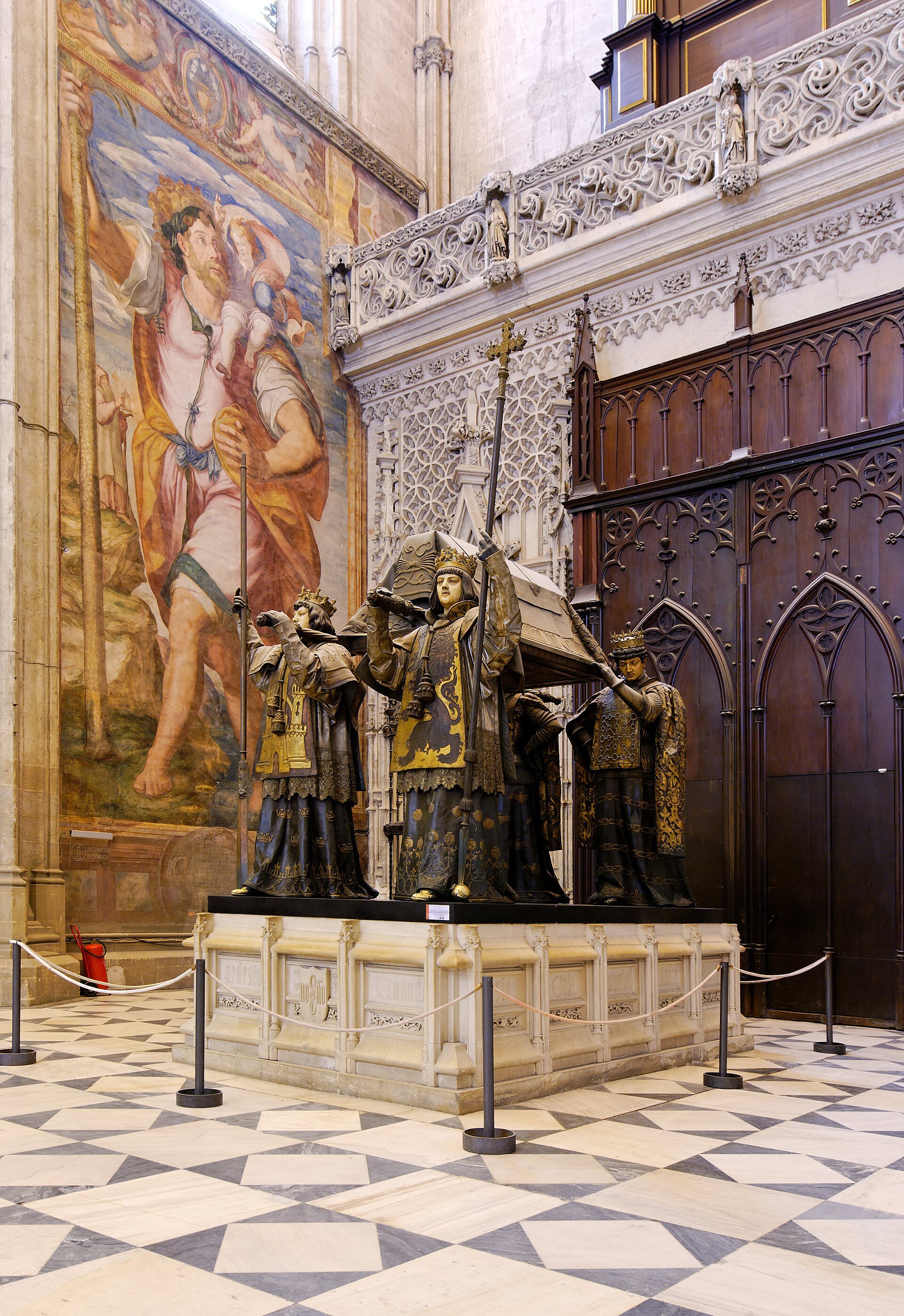 il monumento funebre di cristoforo colombo nella cattedrale di siviglia, con quattro araldi di bronzo che portano la bara sulle spalle