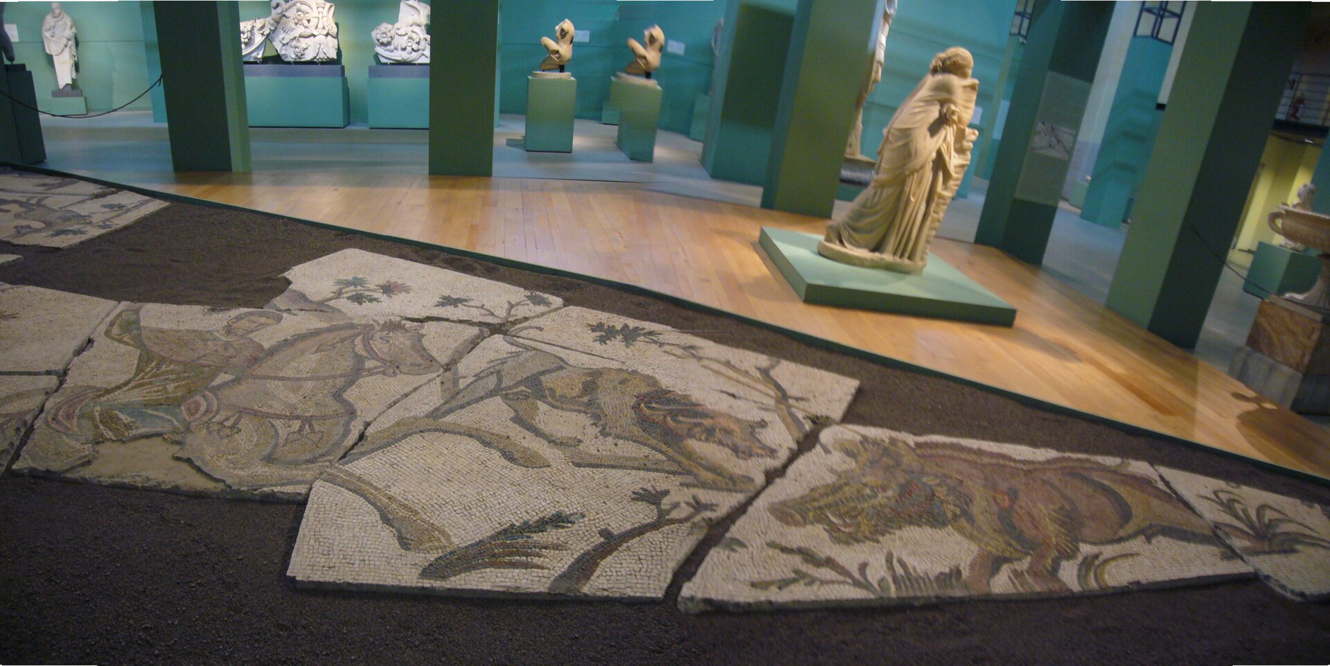 i pannelli del mosaico con scene di caccia posati sul pavimento della sala caldaie, con cacciatori, uccelli e un animale ferito