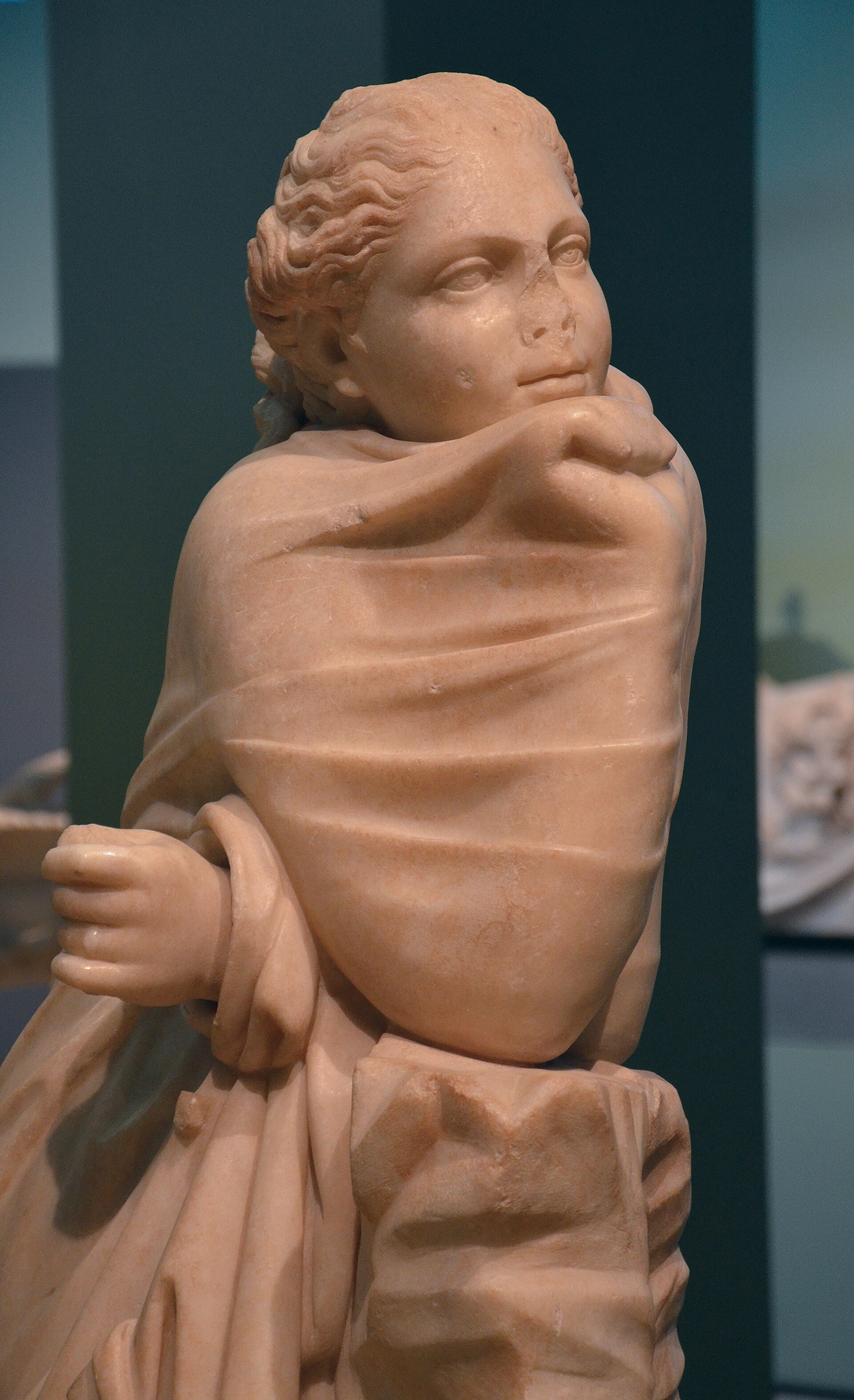 la statua della musa polimnia avvolta nel mantello fino al mento, con la testa girata di lato e il pugno chiuso che esce dalla stoffa