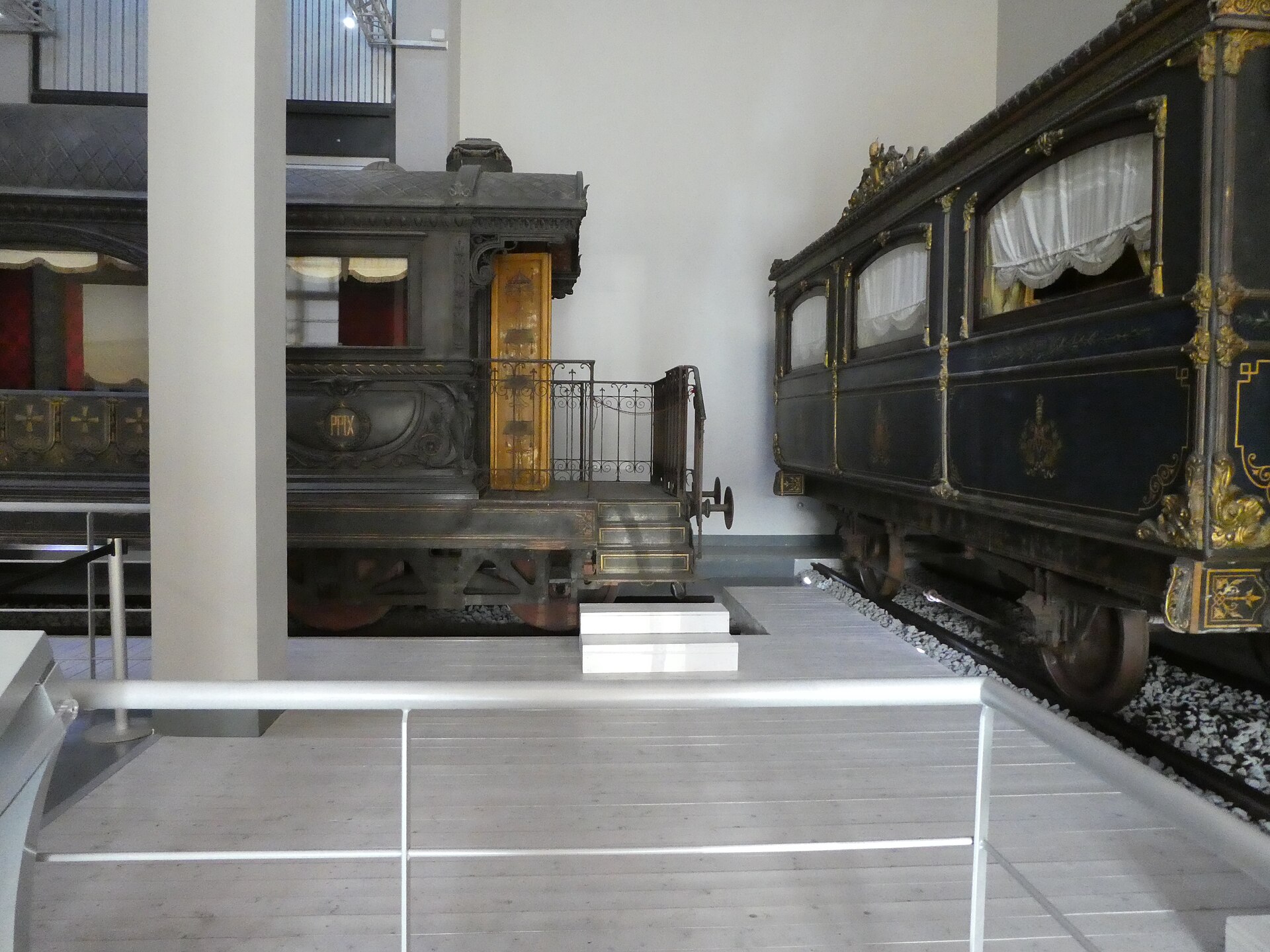 due carrozze del treno di pio ix nella sala del museo, una con la loggia aperta e la ringhiera in ferro battuto, l altra blu con le decorazioni dorate