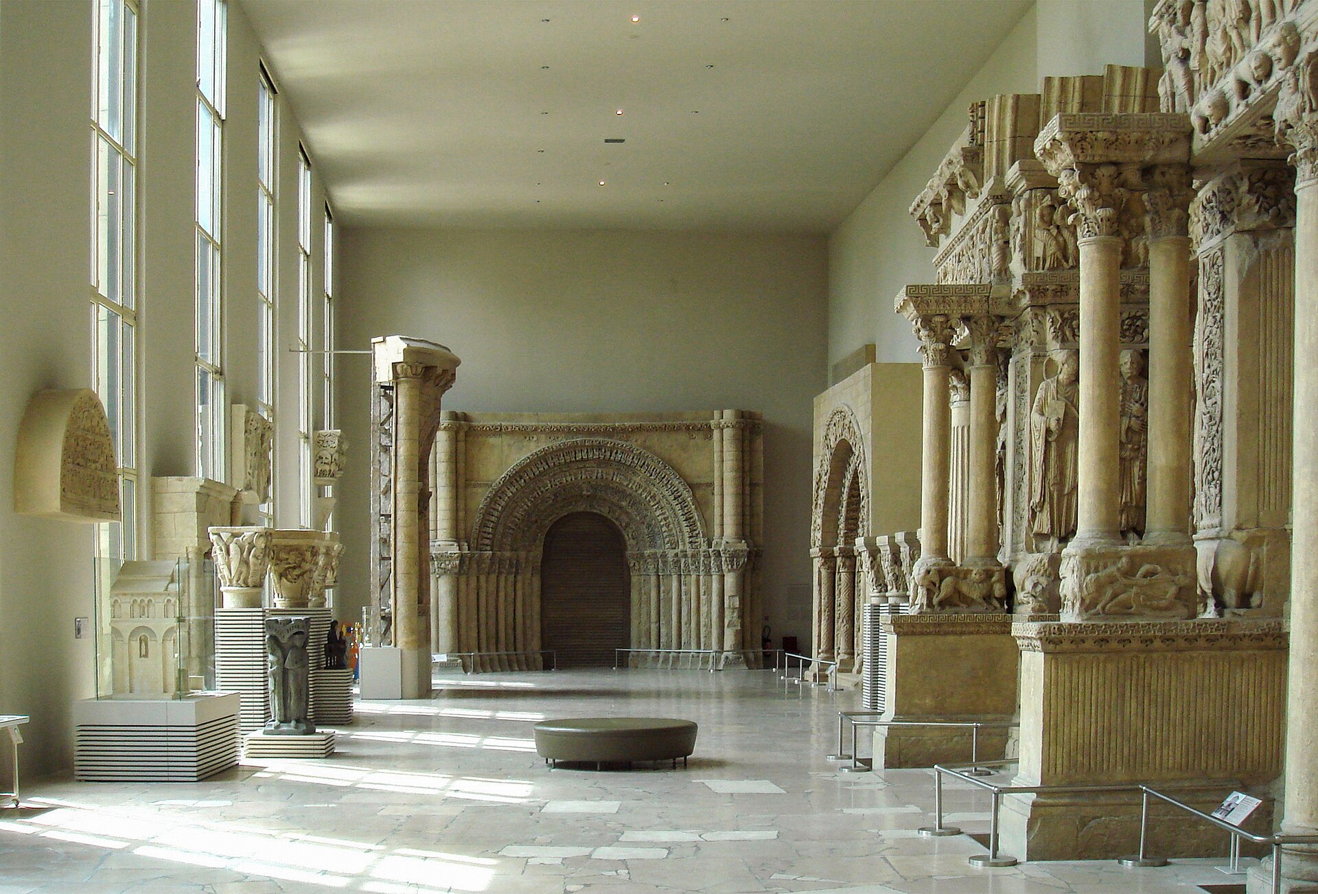 la galleria dei calchi della cite de l architecture, una sala lunga e chiara con vetrate a sinistra e portali romanici in gesso a grandezza naturale a destra