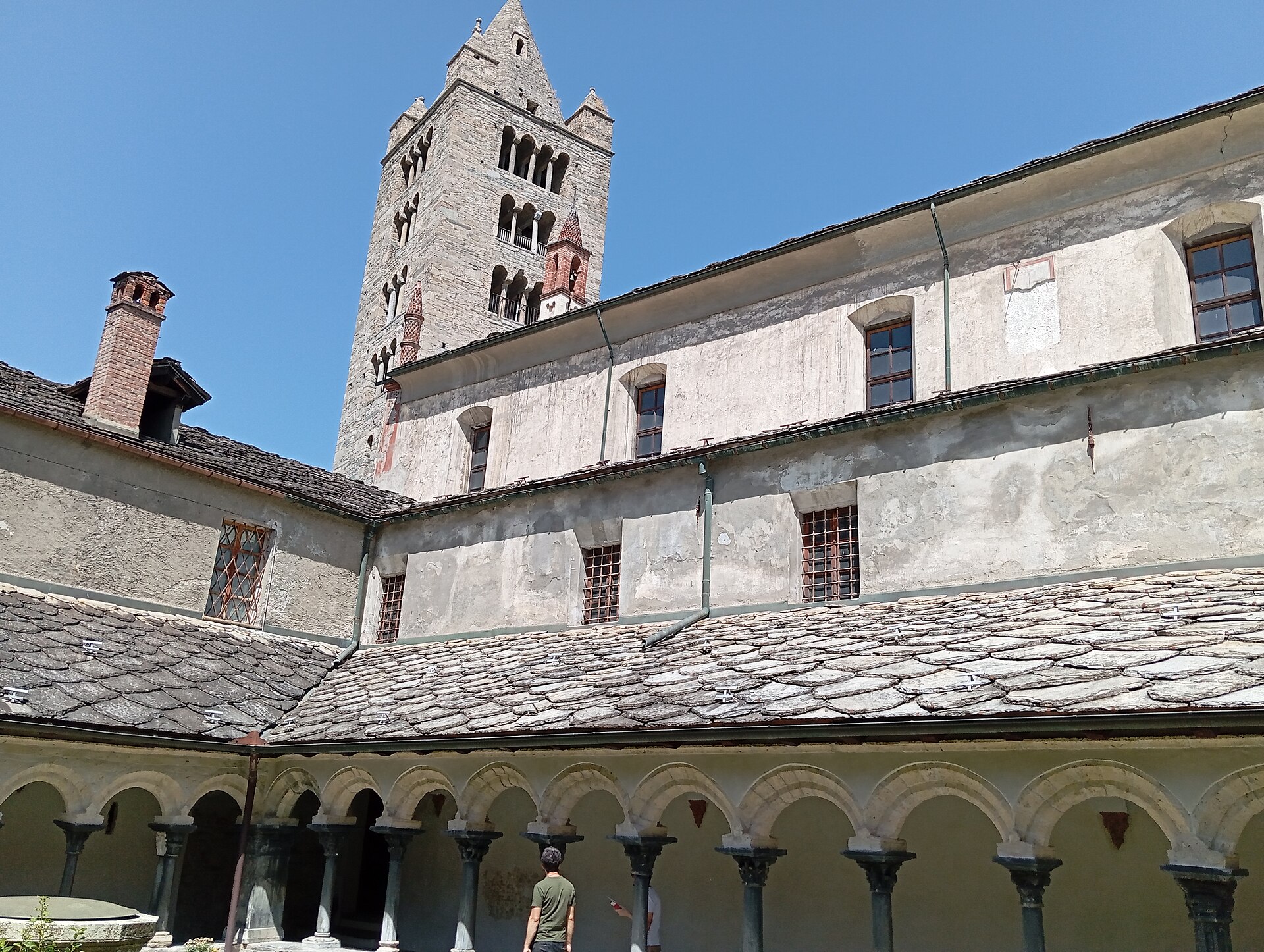 il campanile romanico di sant orso visto dal chiostro, con le bifore e le guglie sopra il tetto in lose