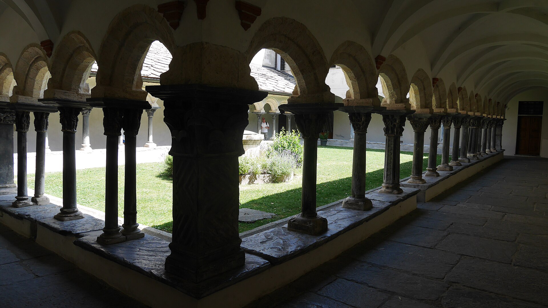 la galleria del chiostro di sant orso ad aosta, con la fila di colonne binate e i capitelli scolpiti sotto la volta