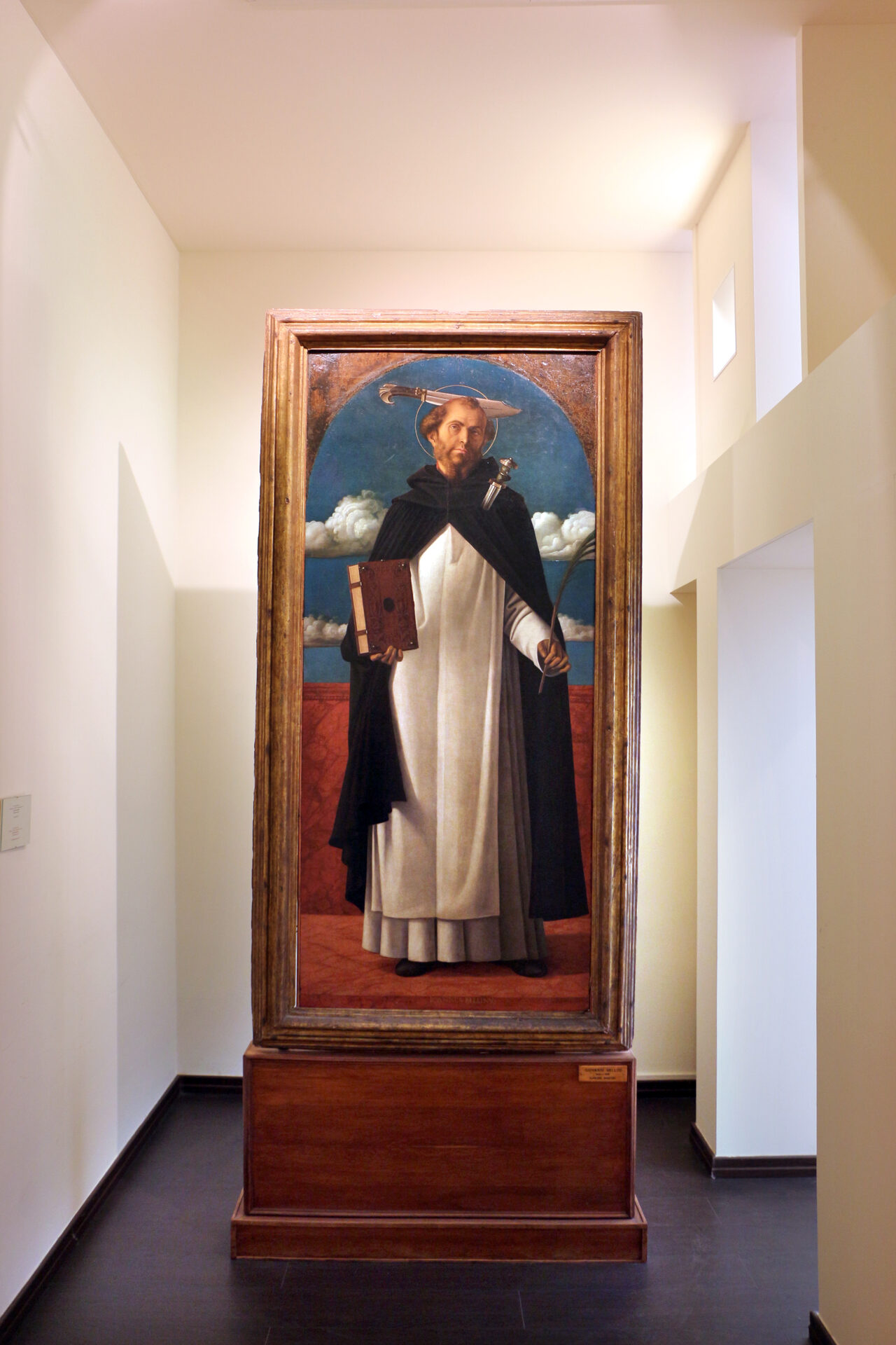 giovanni bellini’s san pietro martire in the pinacoteca of bari, the saint in dominican habit with the billhook in his head