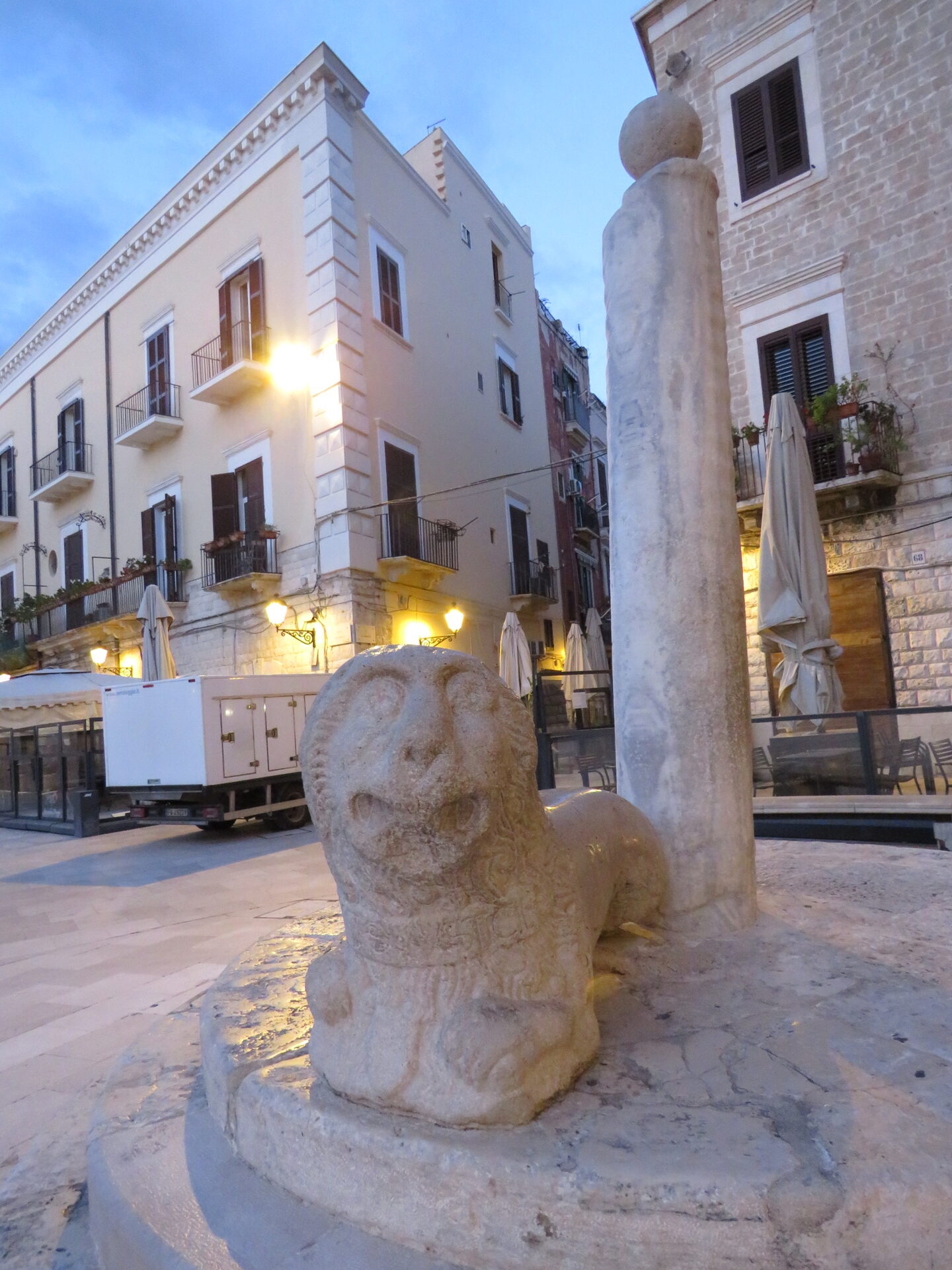 the column of justice in piazza mercantile in bari at dusk, resting on its stone lion