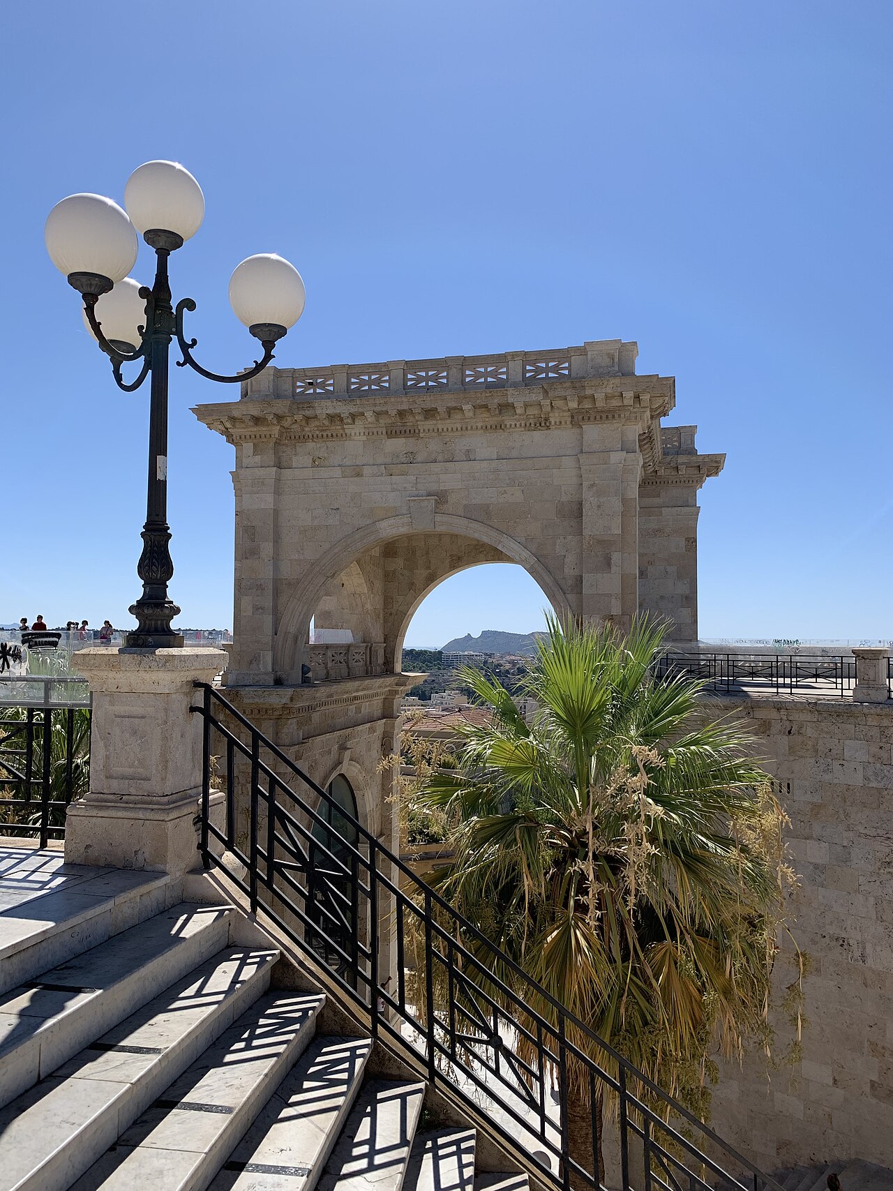 la sella del diavolo vista attraverso l arco del bastione di saint remy con una palma e la scalinata