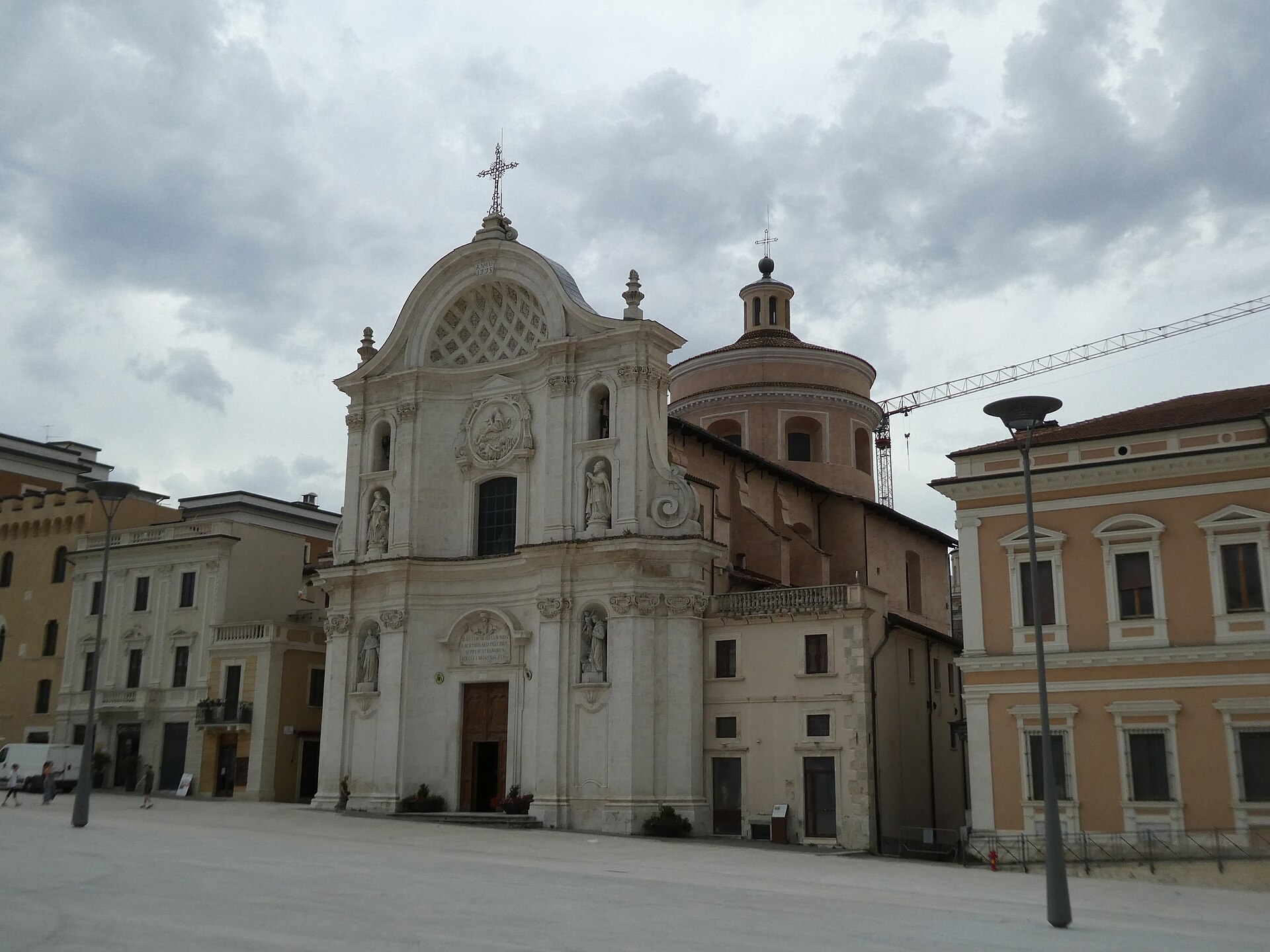 la chiesa di santa maria del suffragio all aquila con la facciata bianca la cupola e una gru ancora in piedi accanto