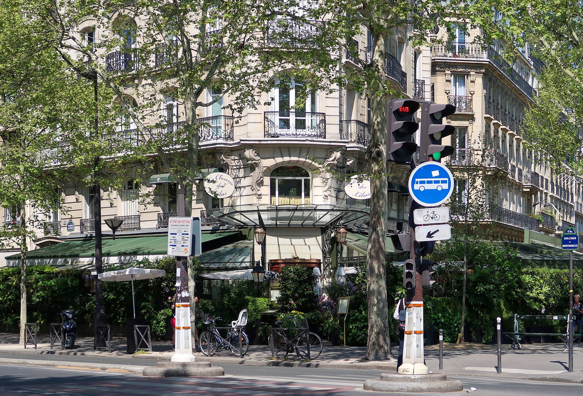 la closerie des lilas all angolo del boulevard du montparnasse a parigi, con le due insegne ovali bianche, le tende verdi, la pensilina di vetro sull ingresso e la siepe che chiude la terrazza