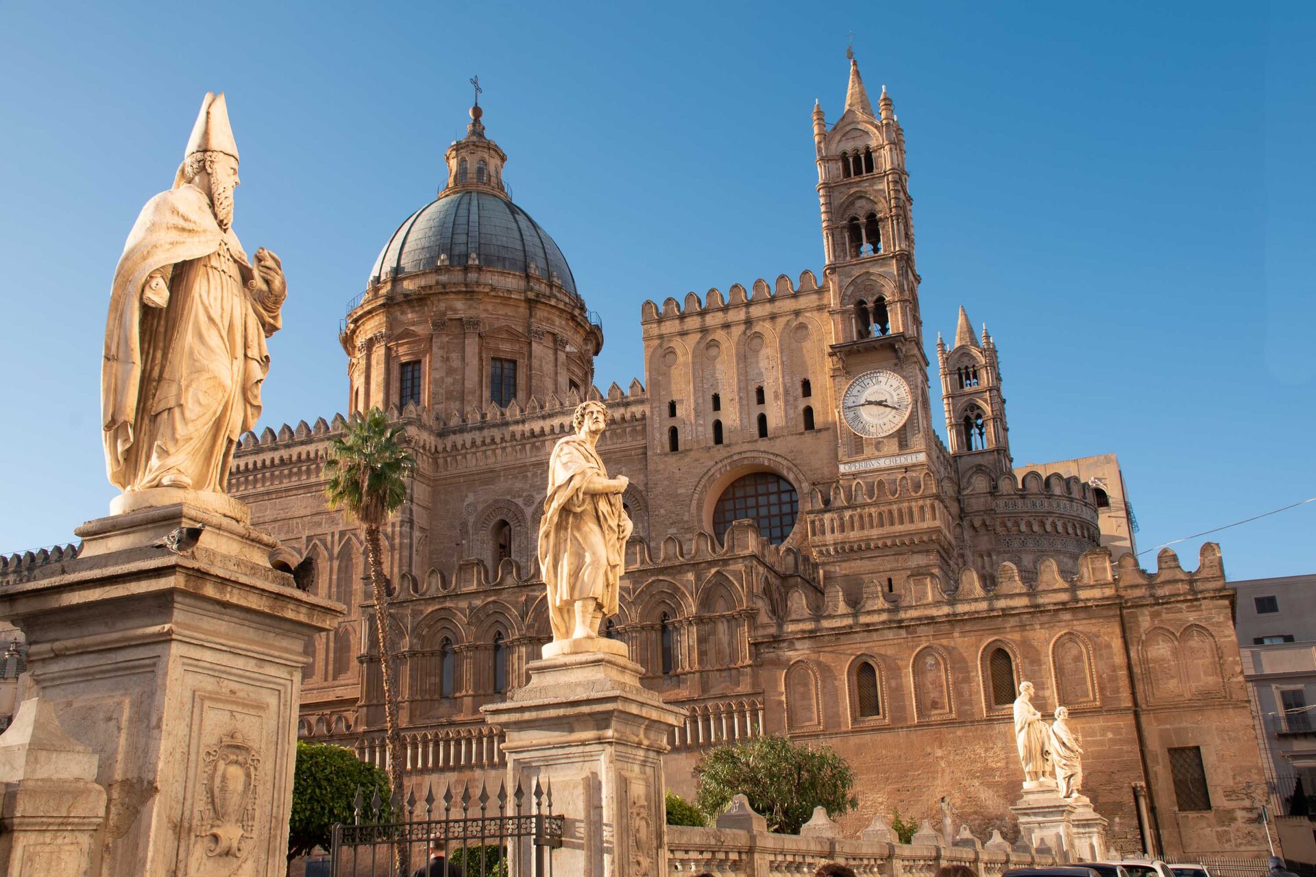 palermo cathedral seen from the south with its domes crenellated towers and the statues of the saints on the wall