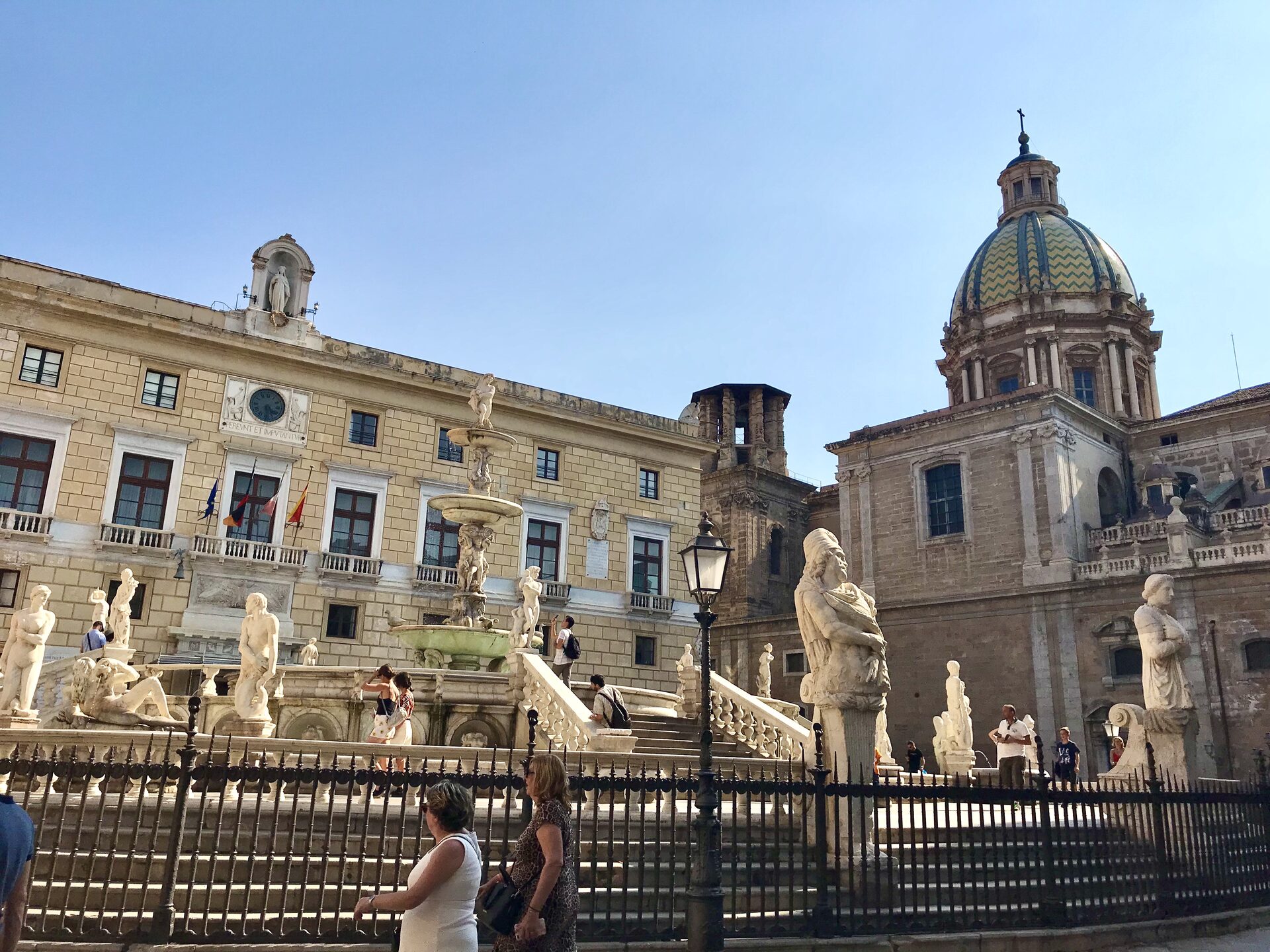 the fontana pretoria in palermo with its white marble statues and the dome of santa caterina behind