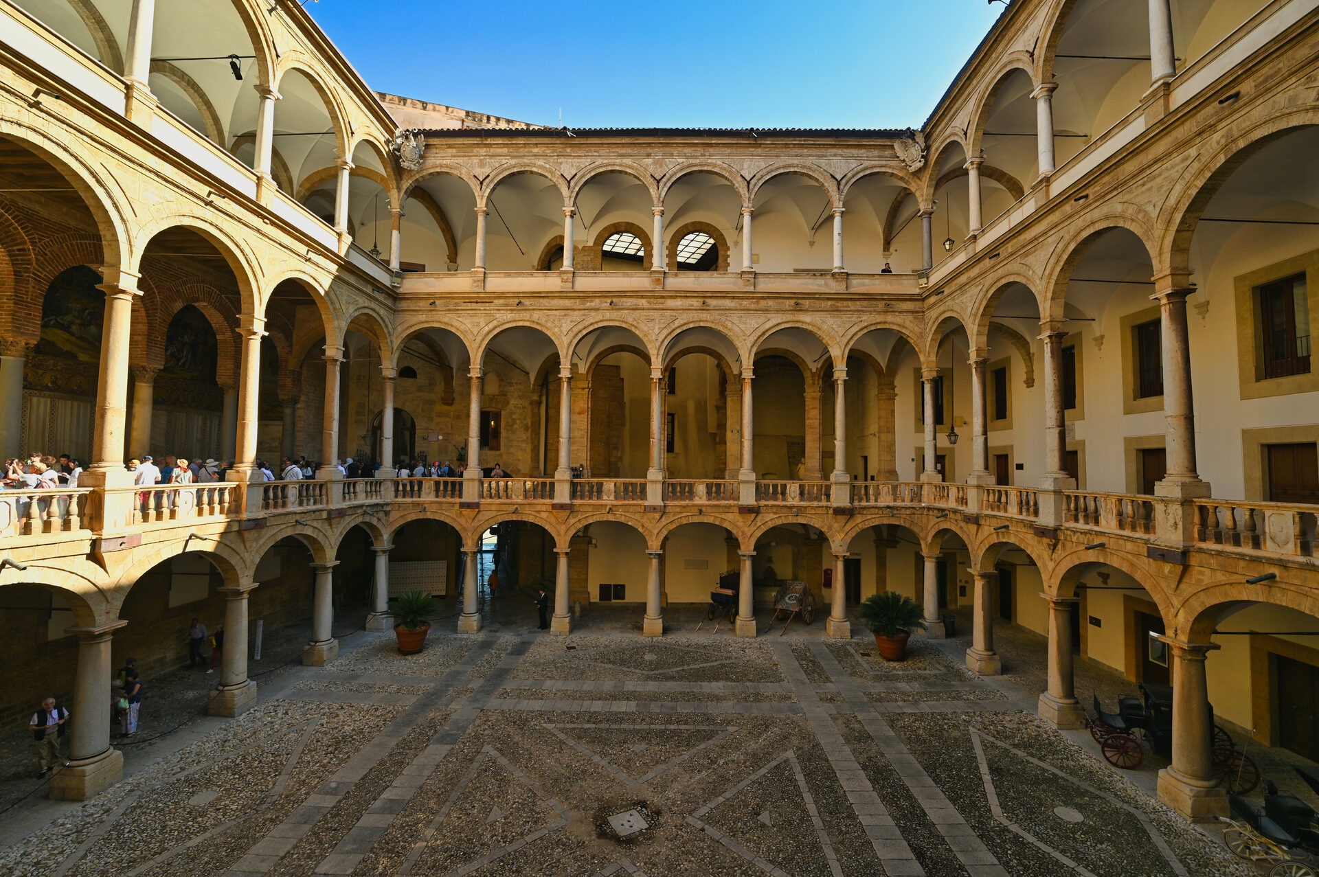 the maqueda courtyard of the palazzo dei normanni in palermo with three tiers of loggias and the lozenge paving
