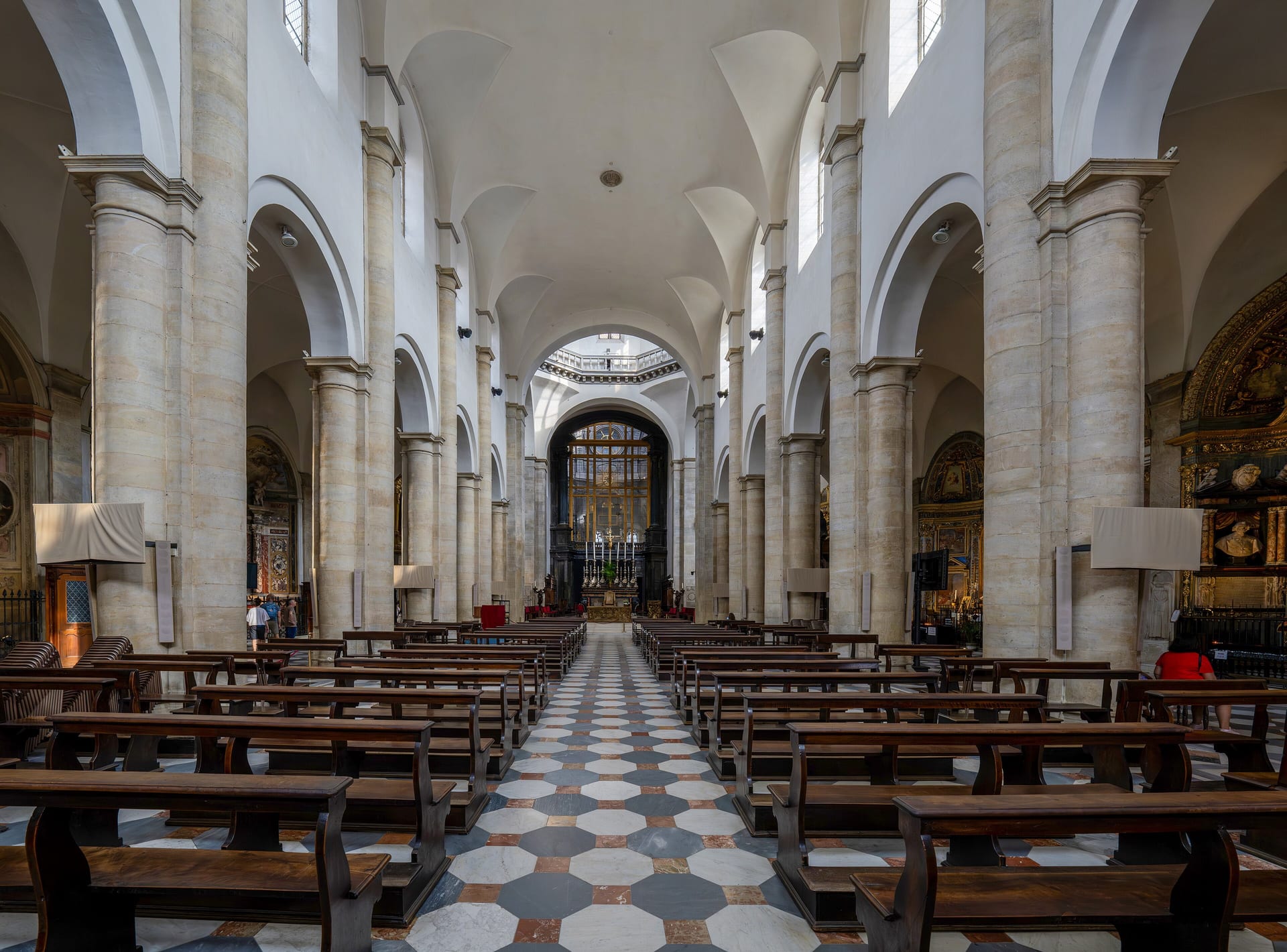 the nave of turin cathedral with pale pillars and a floor of white and grey chequers
