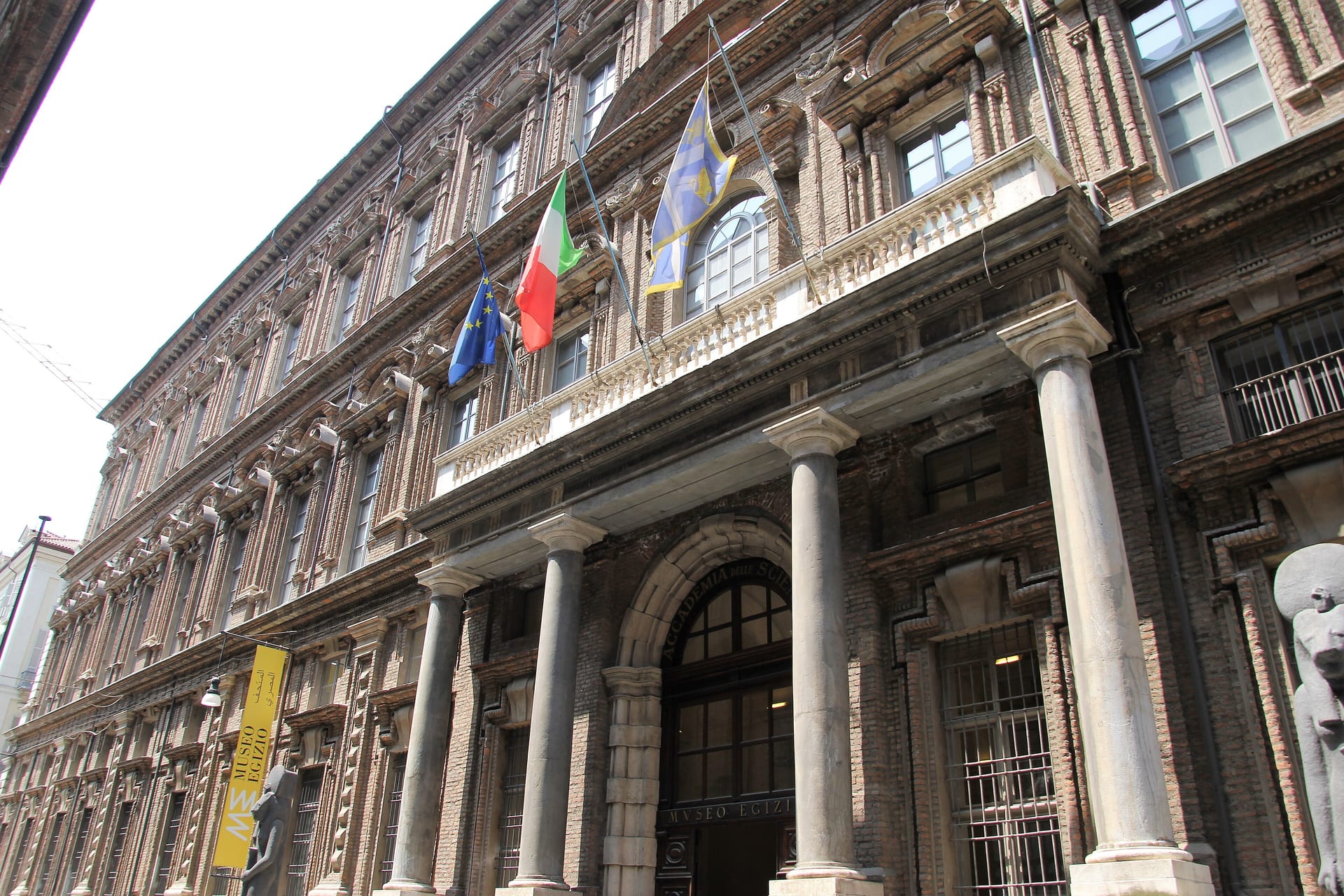the facade of the collegio dei nobili palace in turin, home of the museo egizio, with the columns and banner at the entrance