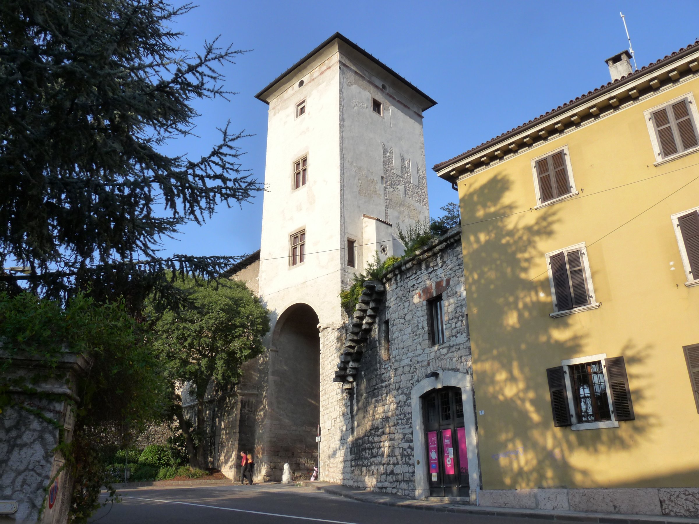 la torre aquila a trento vista dalla strada con l arco della porta di citta